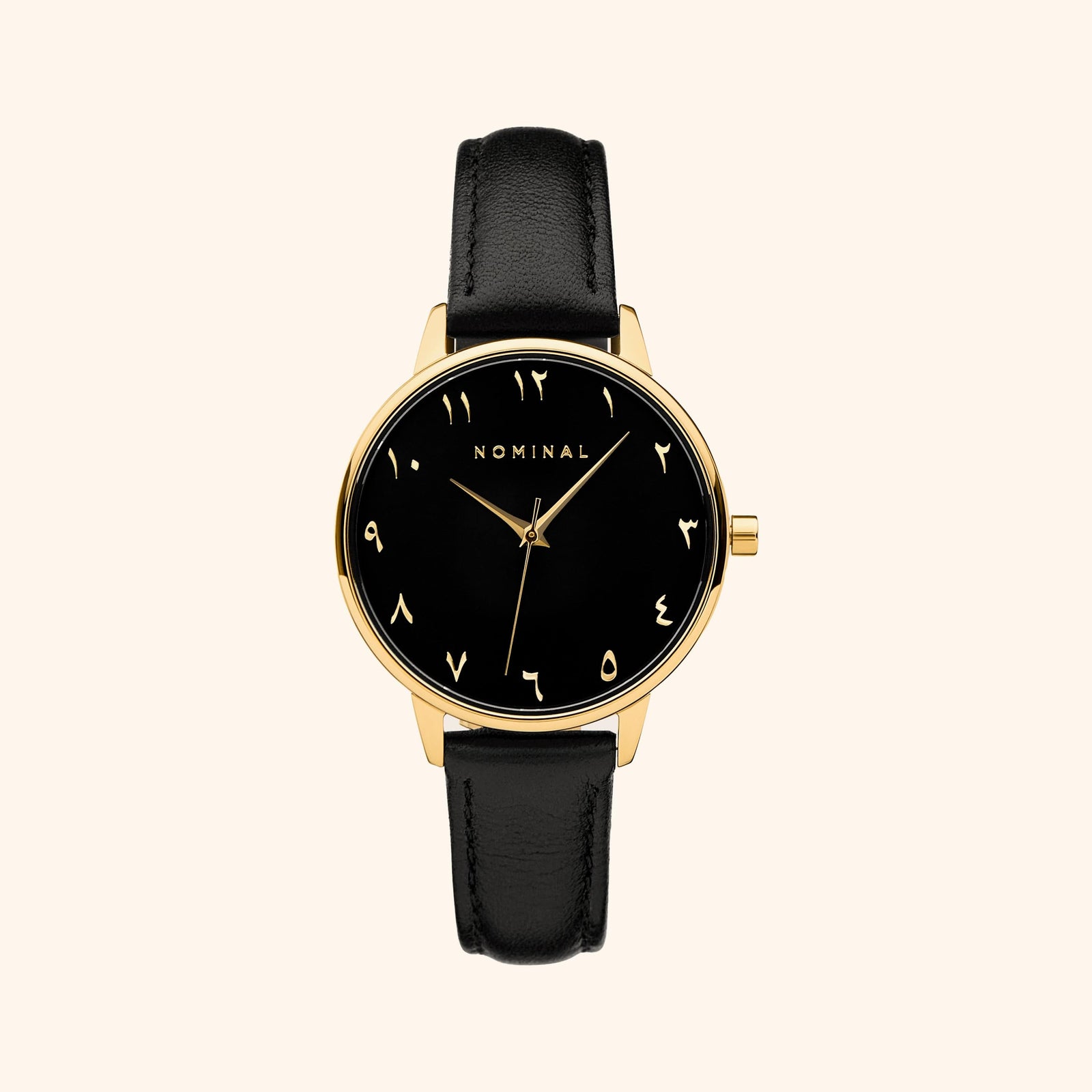 Black mesh strap watch with minimalist Arabic numerals and gold details, displayed against a neutral background