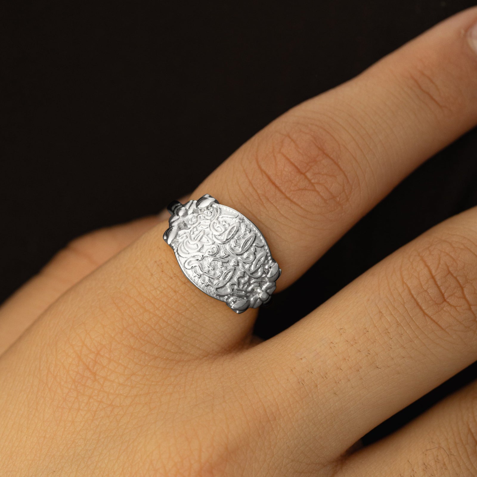 Close up photo of the silver "Walk to Me, and I'll run to you" Medallion Ring as worn by the model.