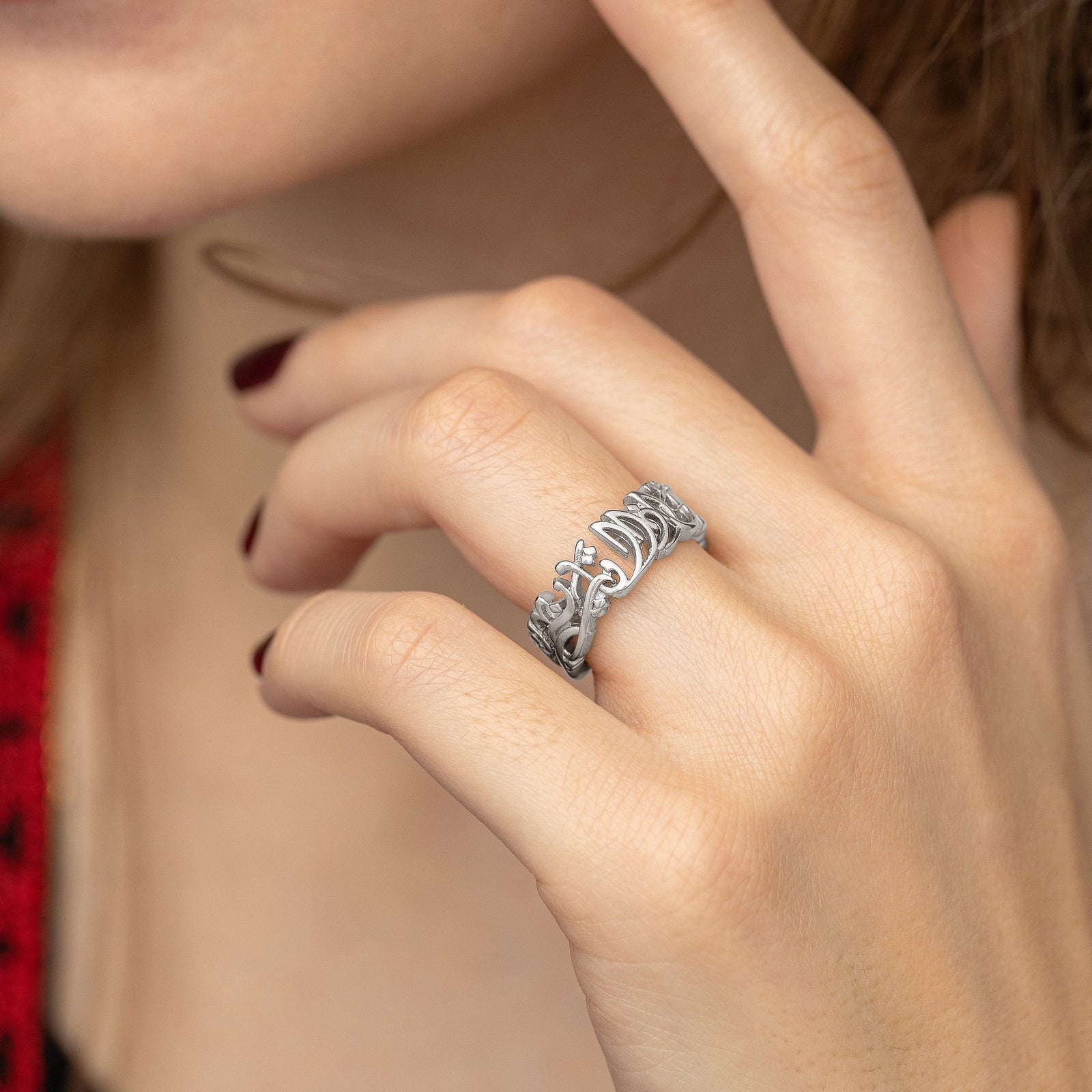 Close up photo of the silver ring worn on the model's left ring finger.
