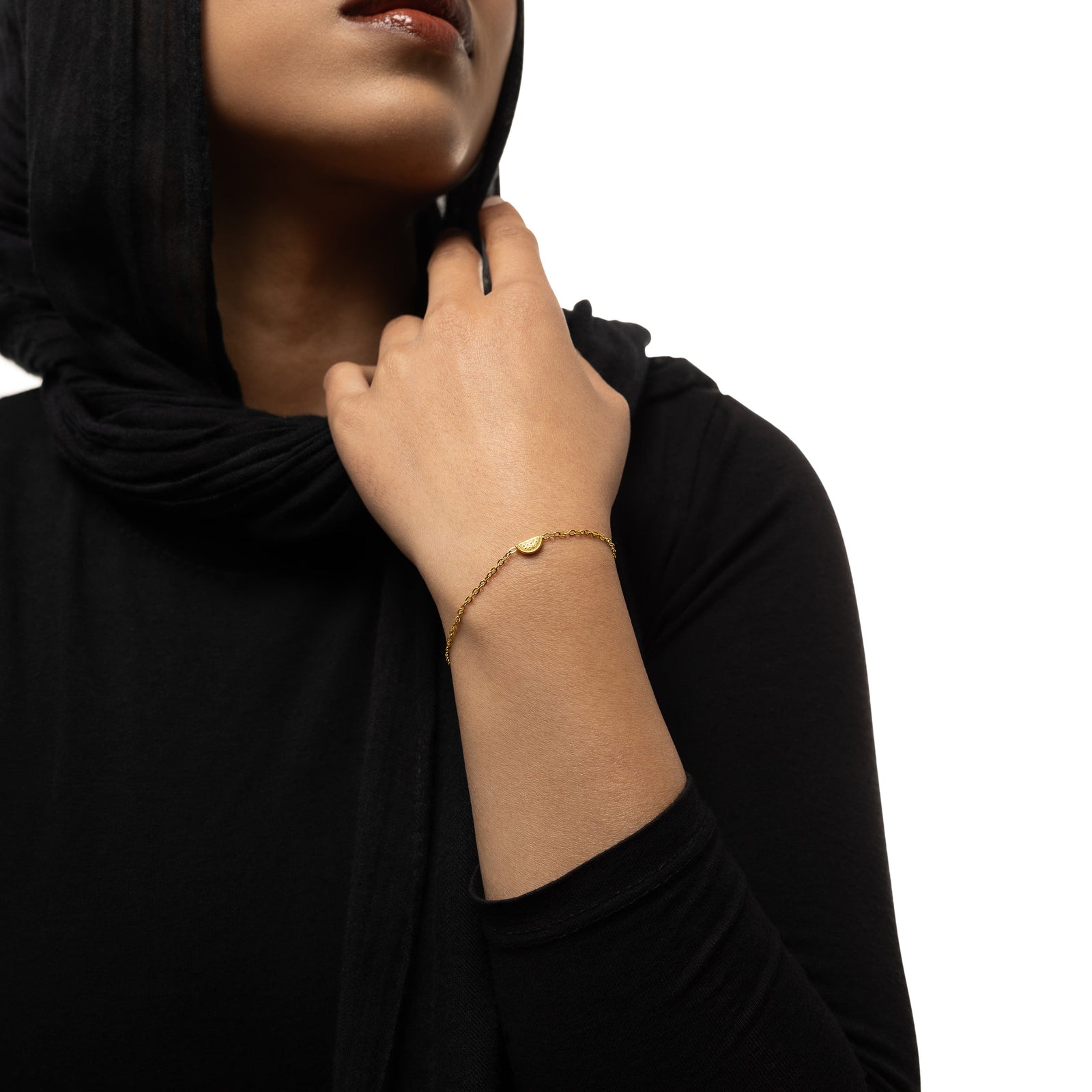 A model wearing the 18K gold-plated Watermelon Bracelet. The bracelet rests gracefully on her wrist, highlighting the subtle watermelon slice design against her skin.
