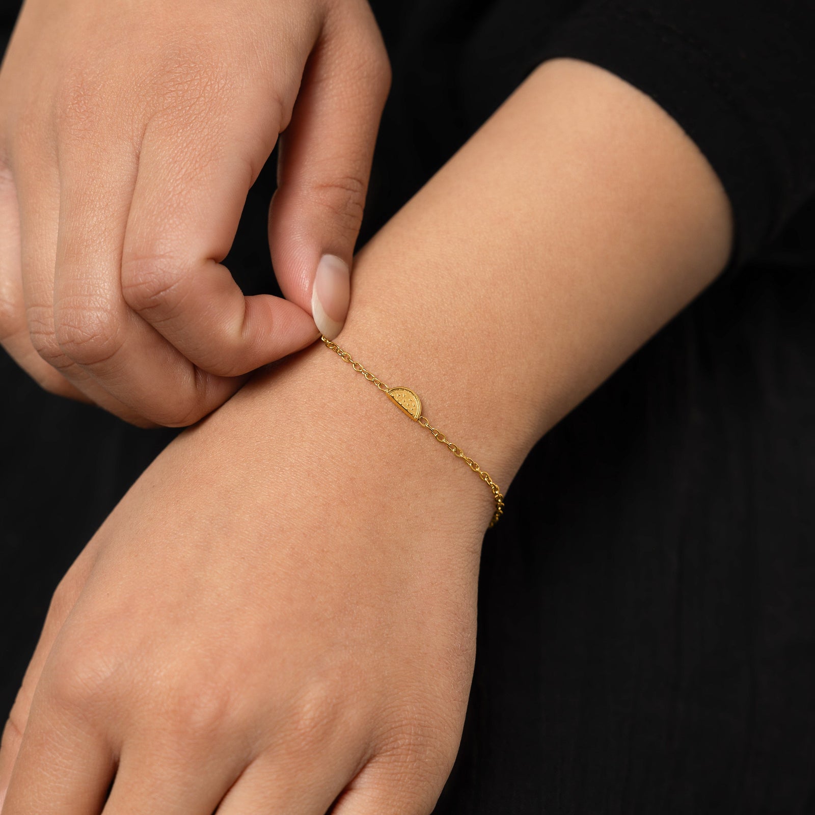 A model wearing the 18K gold-plated Watermelon Bracelet. The bracelet rests gracefully on her wrist, highlighting the subtle watermelon slice design against her skin.