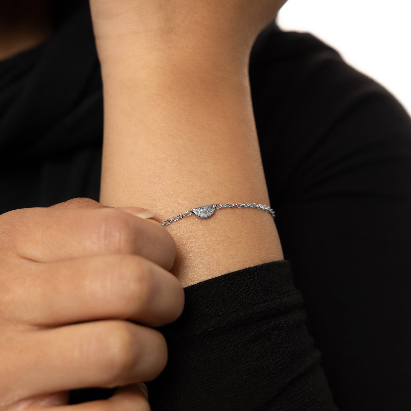 A model showcasing the silver Watermelon Bracelet. The bracelet sits elegantly on her wrist, emphasizing the minimalist watermelon slice design against a neutral background.