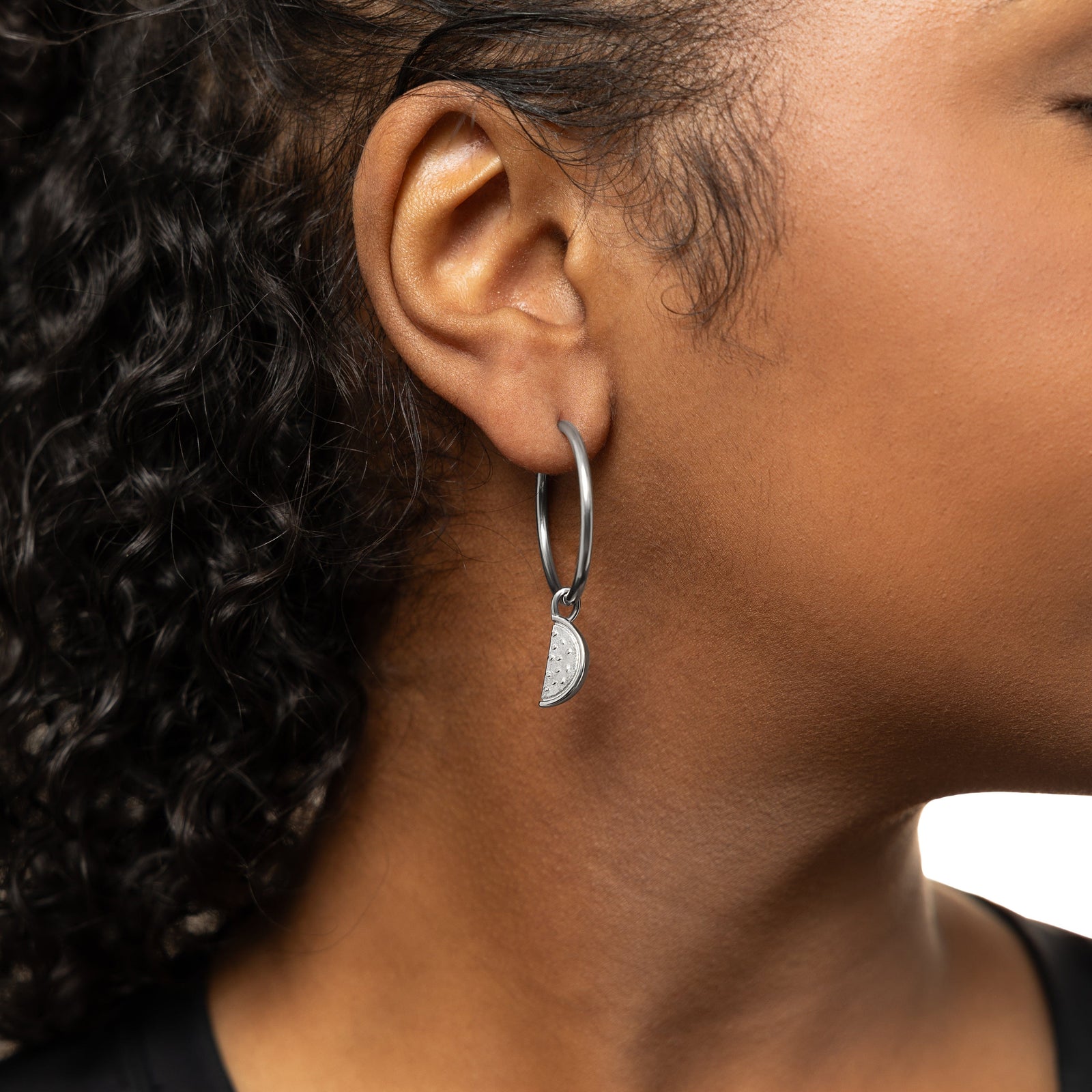 Photo of the silver hoop with a silver Watermelon Earring Hoop Charm on the model's right ear.