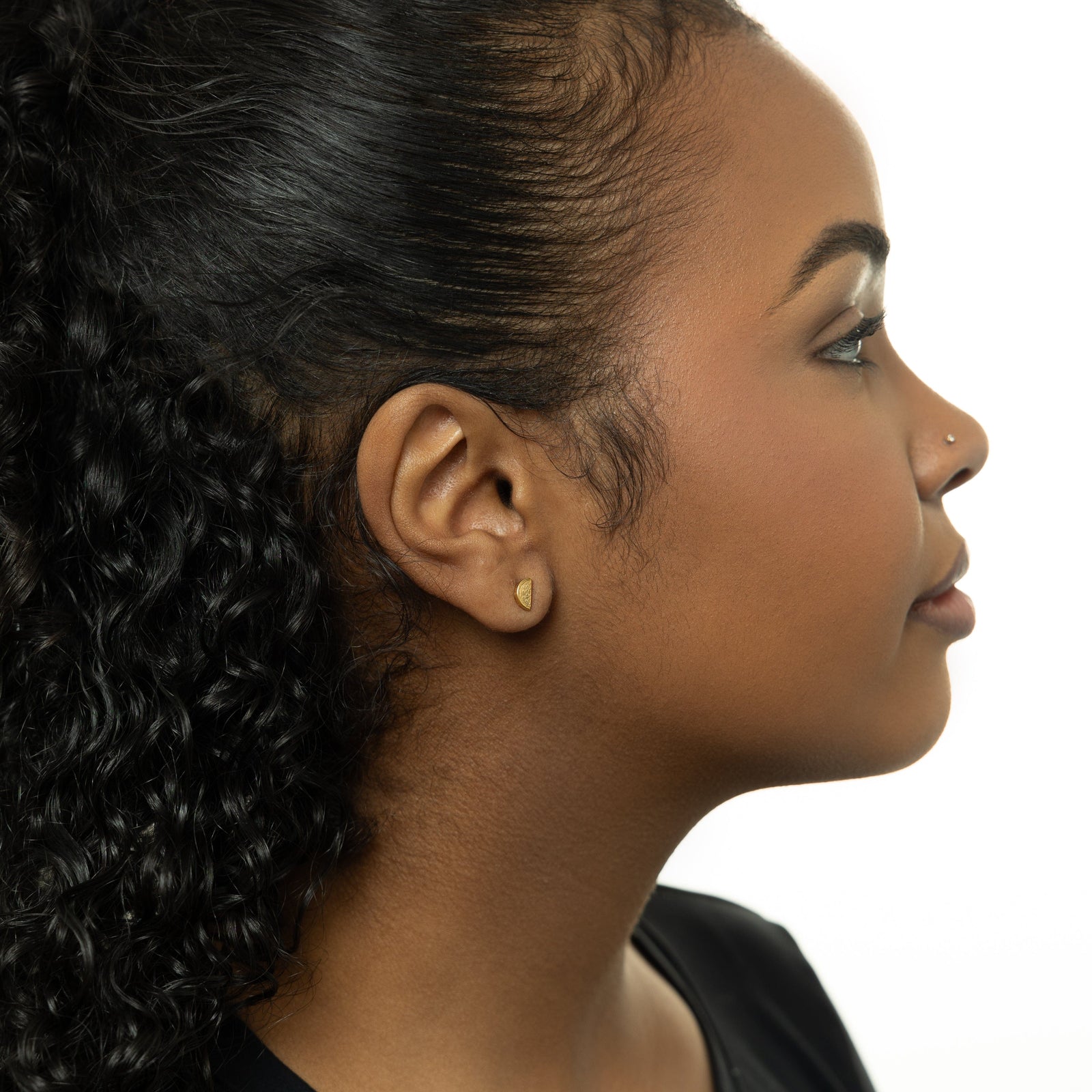 A model wearing the 18K gold-plated Watermelon Studs. The earrings sit delicately on her earlobes, highlighting the vibrant watermelon design against her skin.
