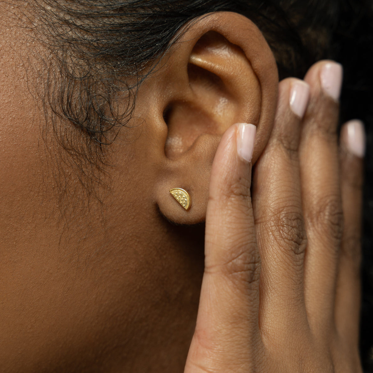 A model wearing the 18K gold-plated Watermelon Studs. The earrings sit delicately on her earlobes, highlighting the vibrant watermelon design against her skin.