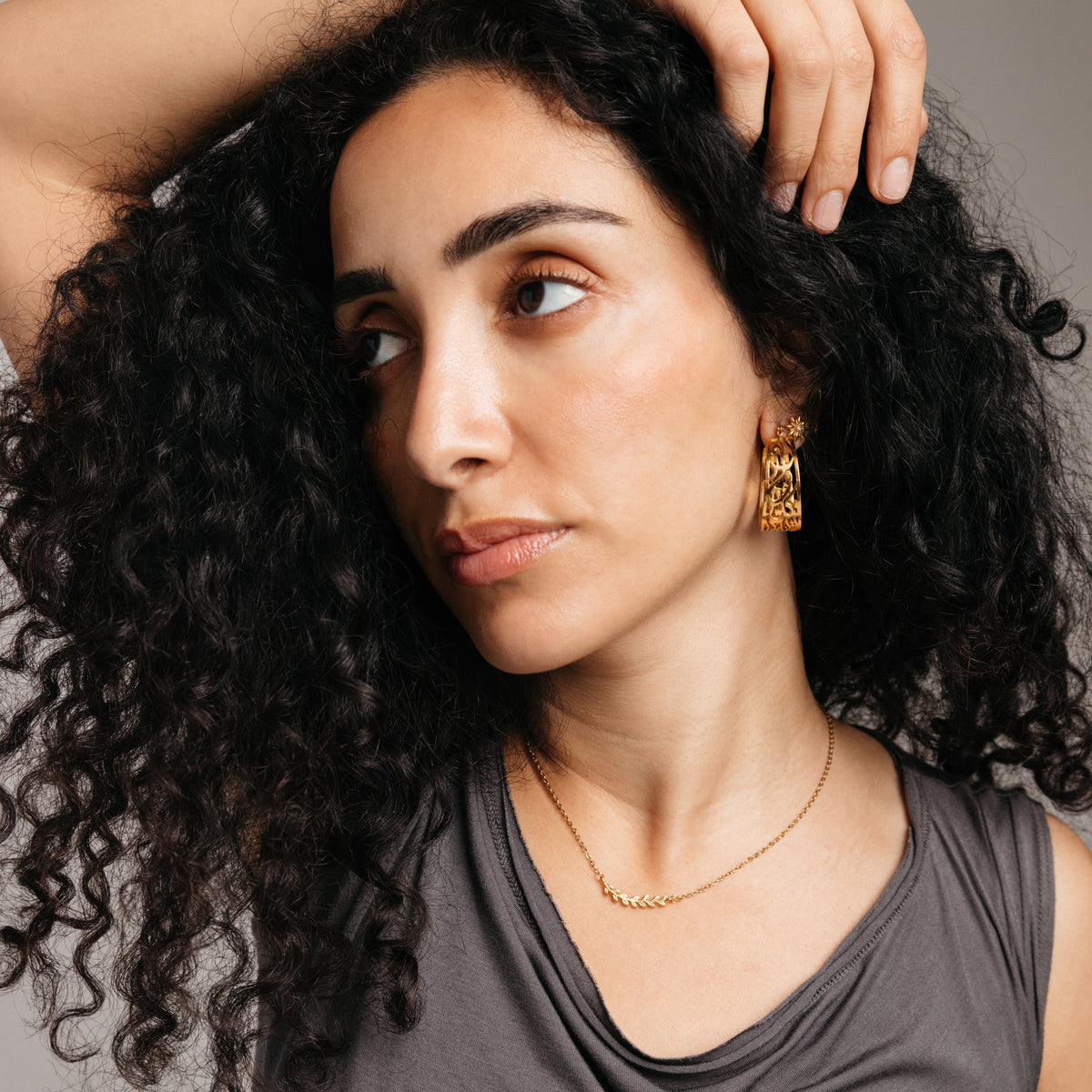 Model styled in 18k gold-plated Nominal jewelry featuring the Weaving Olive Branch Necklace paired with the Calligraphy Hoops.