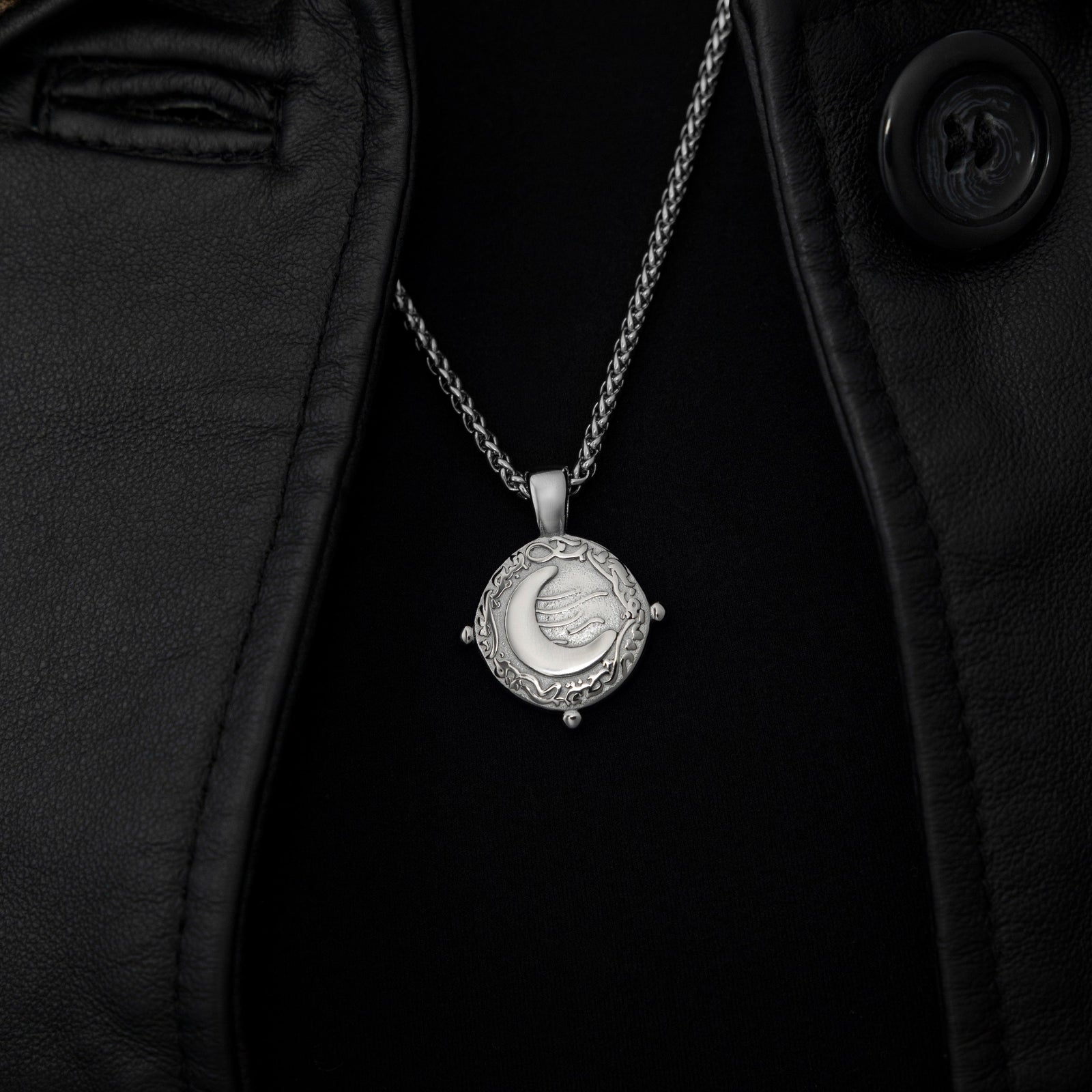 Silver what you seek is seeking youworn over a black top and leather jacket, styled with a taupe and rust hijab. 