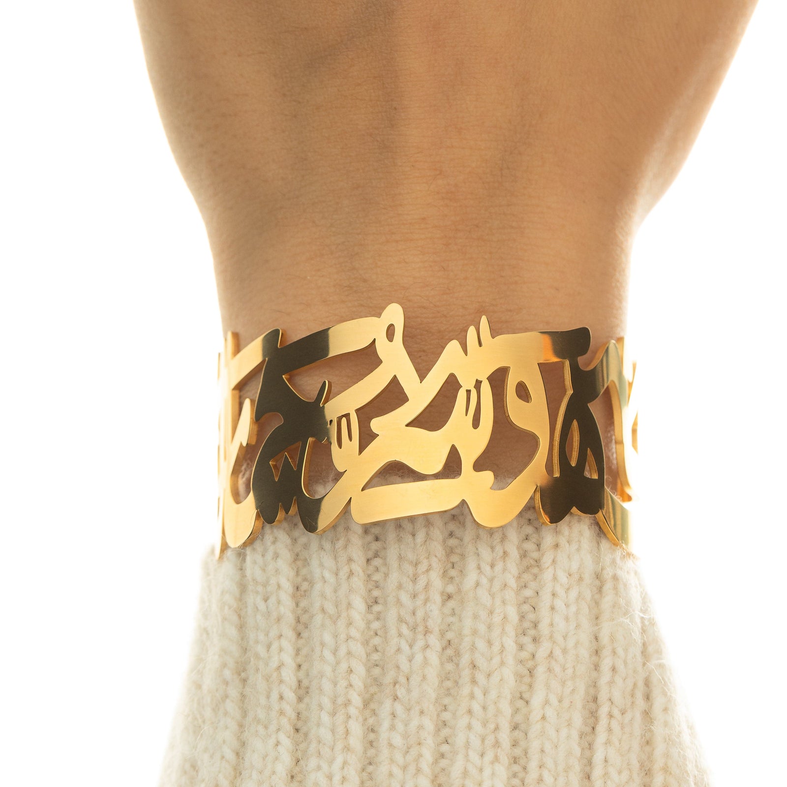 close-up of the ‘What Makes You Different Makes You Beautiful’ Calligraphy Cuff in gold on a wrist, showing the reflective calligraphy details.