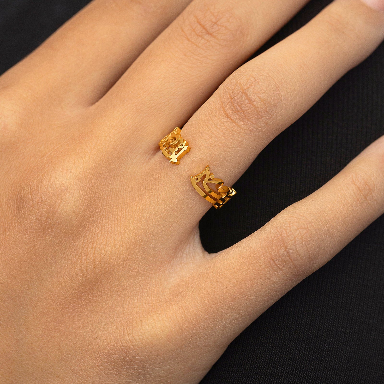 Gold “What Makes You Different Makes You Beautiful” Calligraphy Ring styled on the hand, open-band design visible with the Arabic calligraphy facing upward.