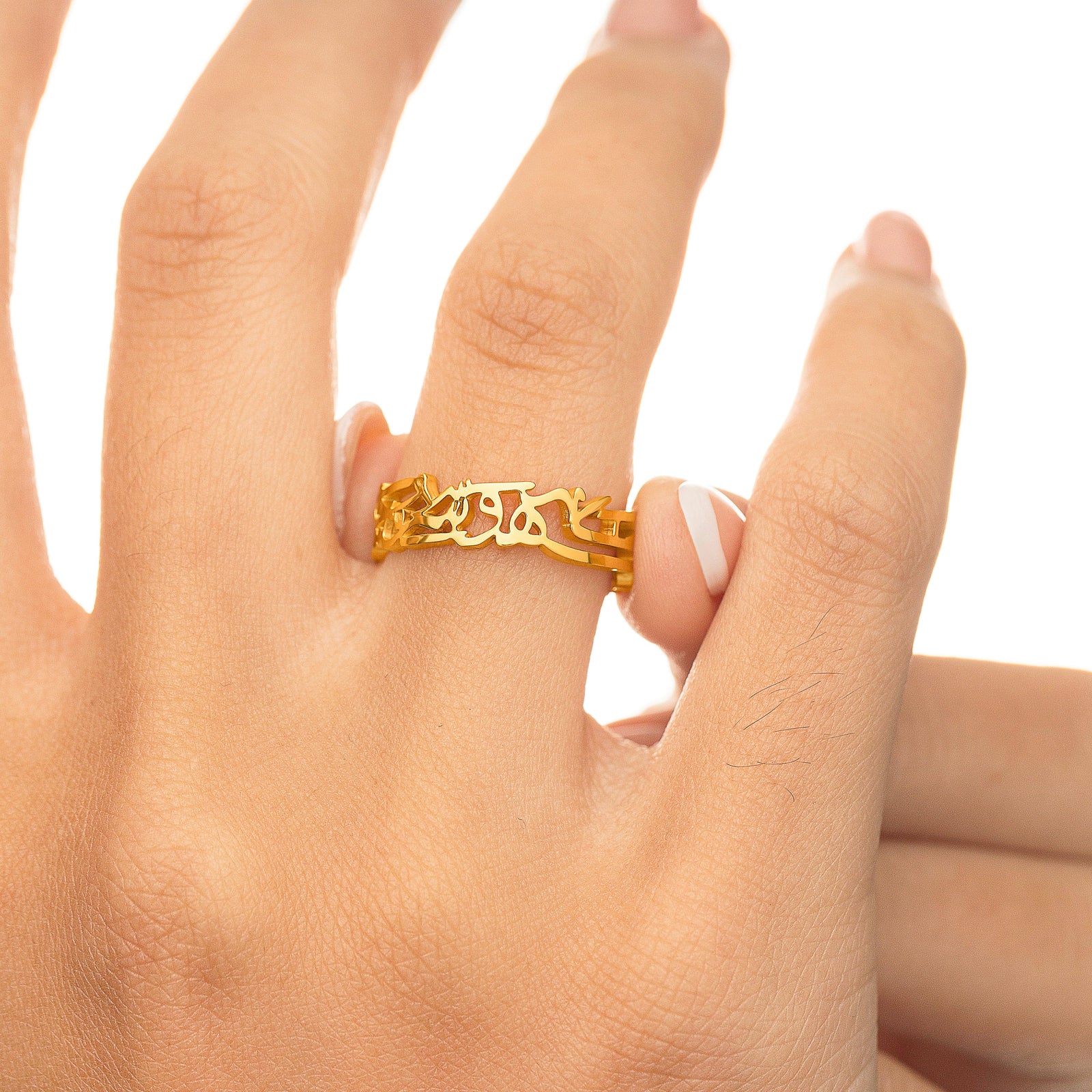 Gold “What Makes You Different Makes You Beautiful” Calligraphy Ring worn on a finger, close-up angle showing the smooth gold finish and cutout calligraphy.