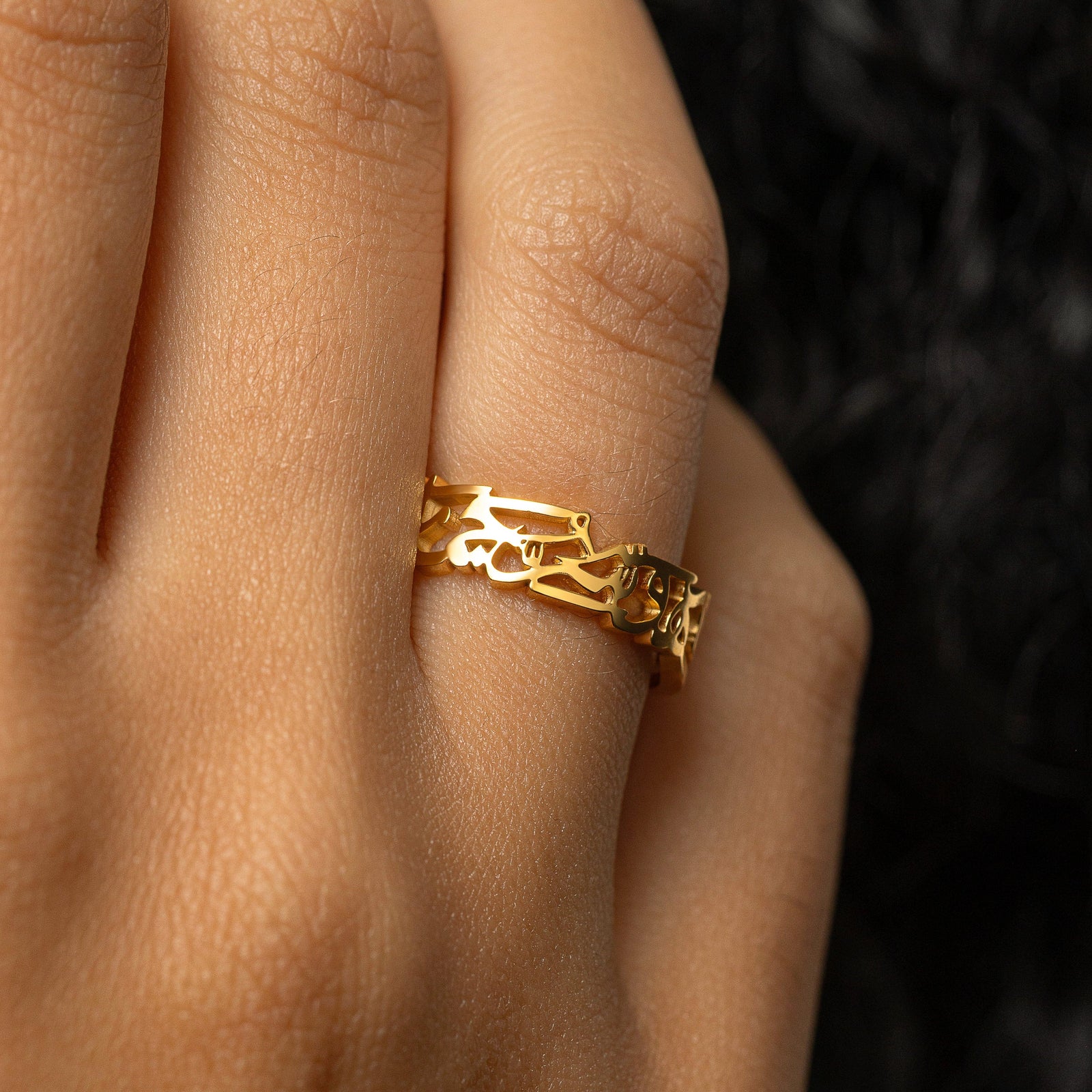 Gold “What Makes You Different Makes You Beautiful” Calligraphy Ring worn on a finger, showing the Arabic calligraphy around the band.