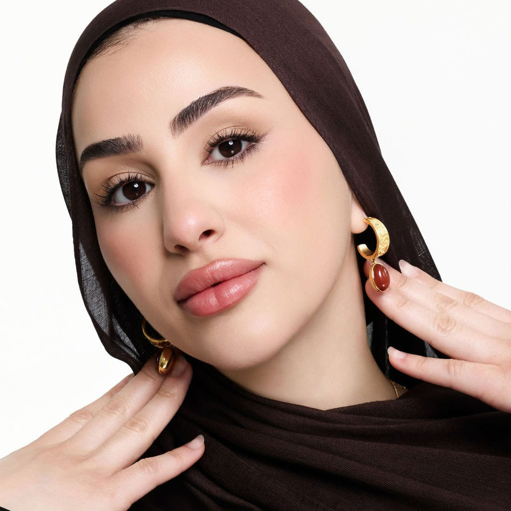 Photo of the model wearing the pair of "With Hardship Comes Ease" Earrings.