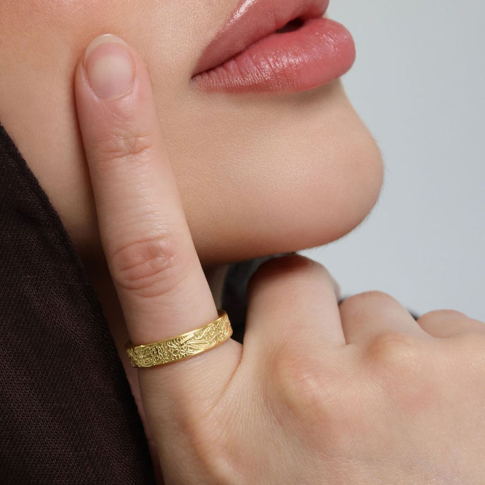 Close up of the gold "With Hardship Comes Ease" Ring V2 as worn by the model.
