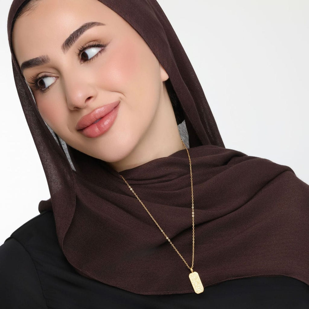 The gold "With Hardship Comes Ease" Tag | Women as worn by the model.