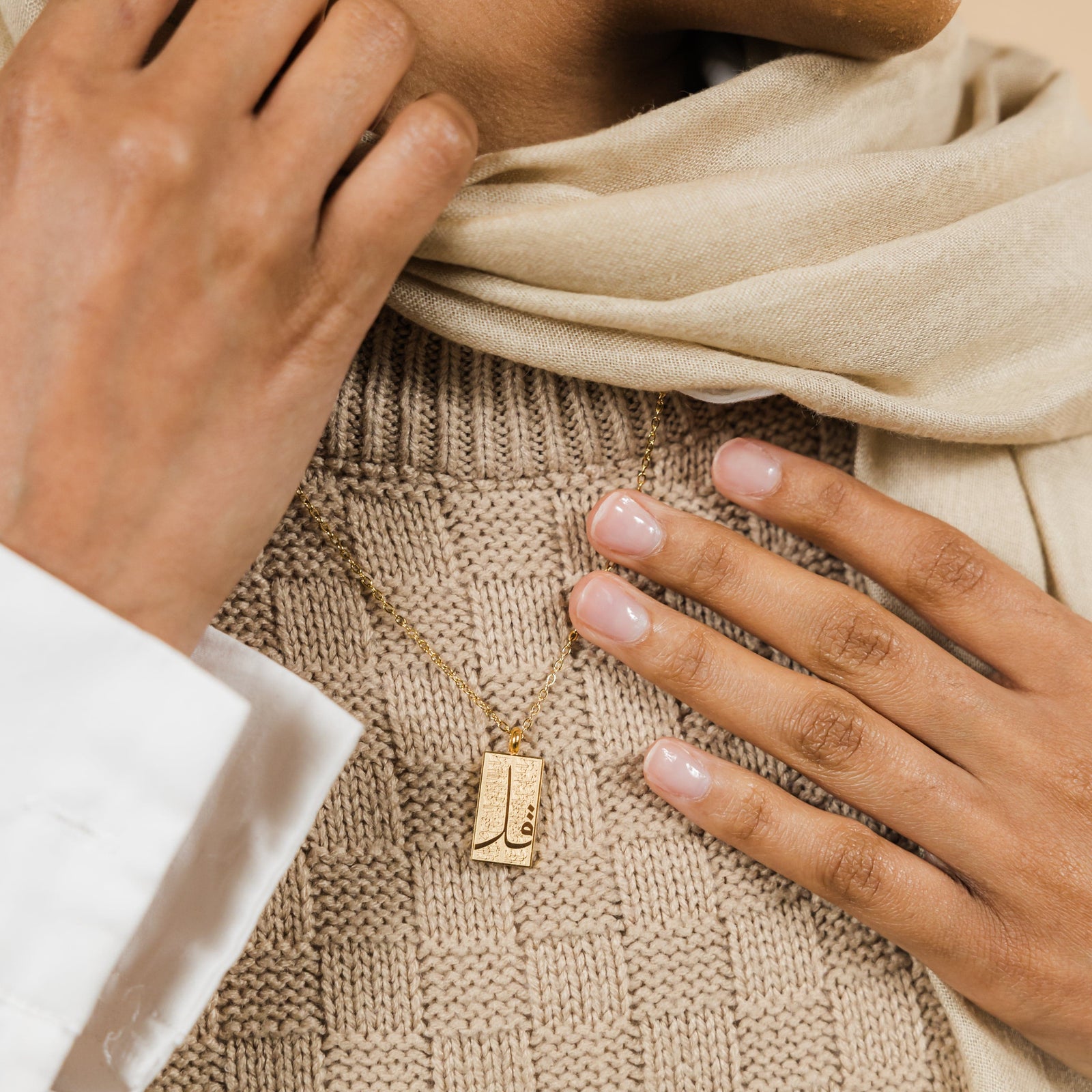 Close up of the gold '4 Qul' Tag Necklace | Women as worn by the model.