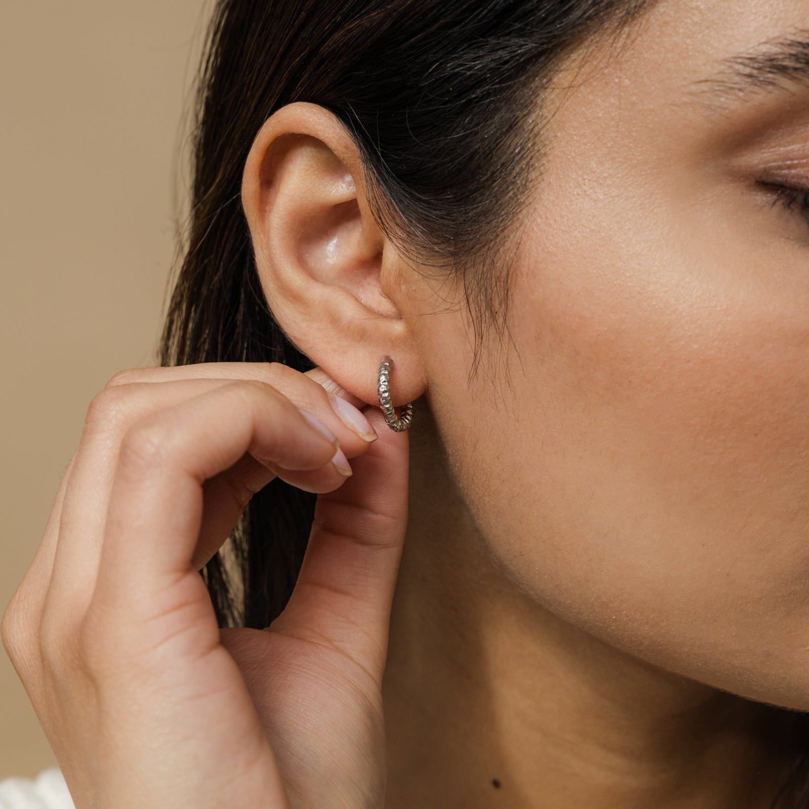 Close up of the silver Flake Hoops as worn by the model on their right ear.