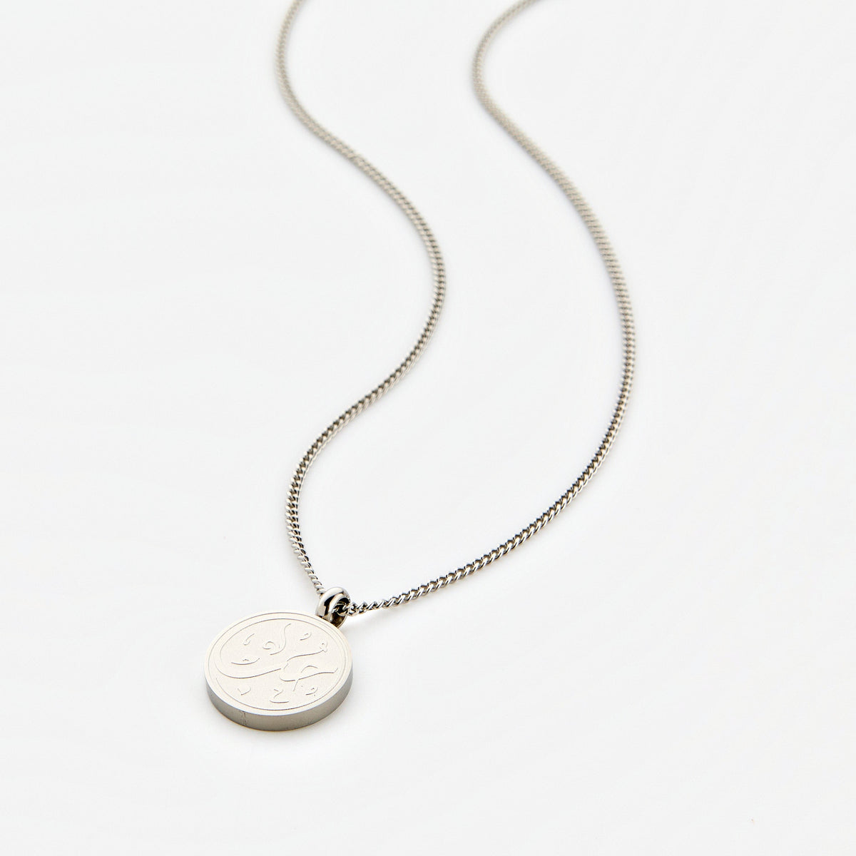 Silver necklace with a circular pendant engraved with 'Hub' calligraphy, displayed on a white background.