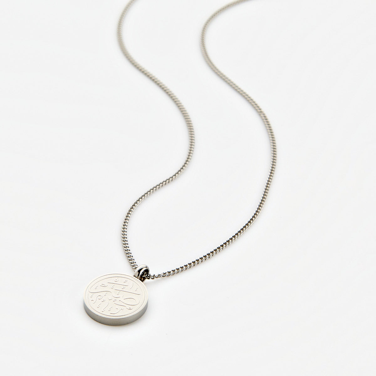 Silver necklace with a circular 'Sabr' calligraphy engraved pendant, displayed on a white background.