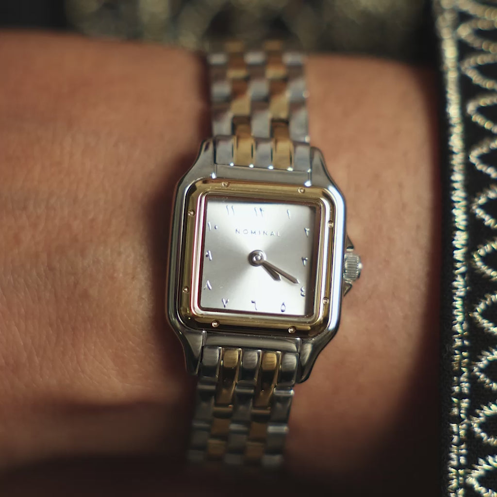 Close up of the Sunrise watch. Model adjusts the watch on their left hand. Model moves their hand to show different angles of the watch. Model adjusts their hijab with their left hand showing the watch they are wearing.