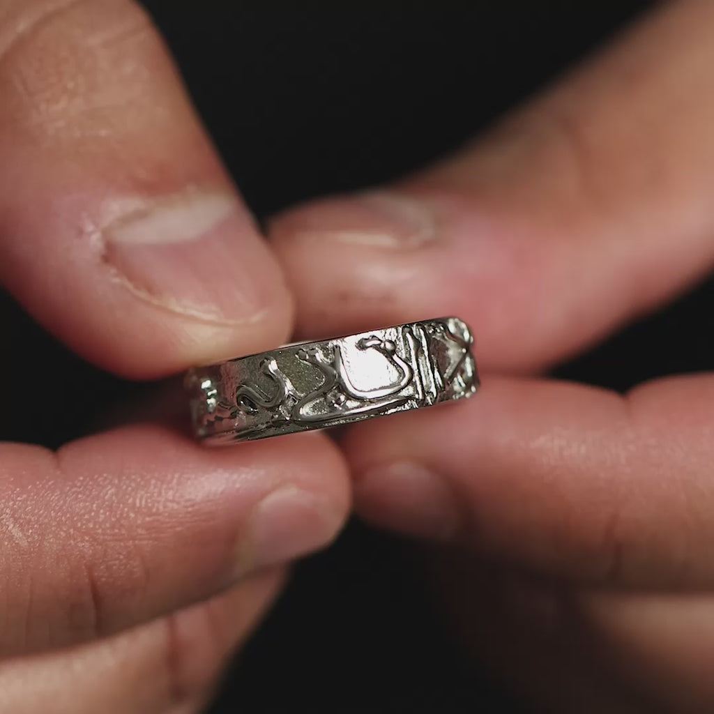 Model holds and rotates the silver "Perhaps you dislike what is good for you" Ring | Men to show its design. The model wears the ring on their finger. Model moves their hand to show the different angles of the ring.