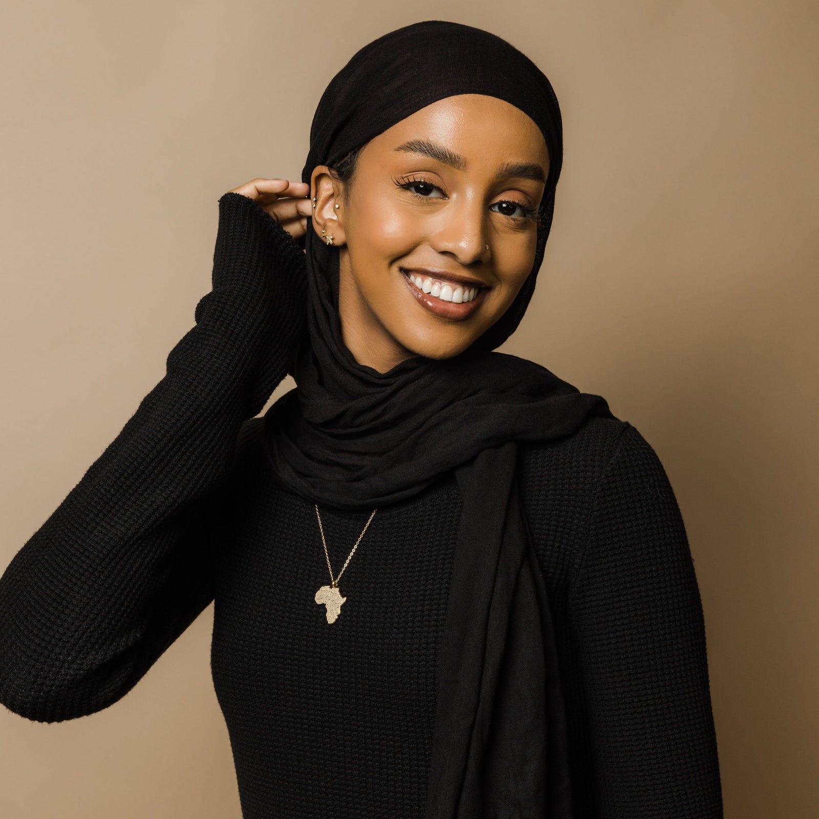 A model wearing the gold-plated Ayatul Kursi Country Map Necklace, with the pendant resting elegantly on her chest, highlighting the intricate design.