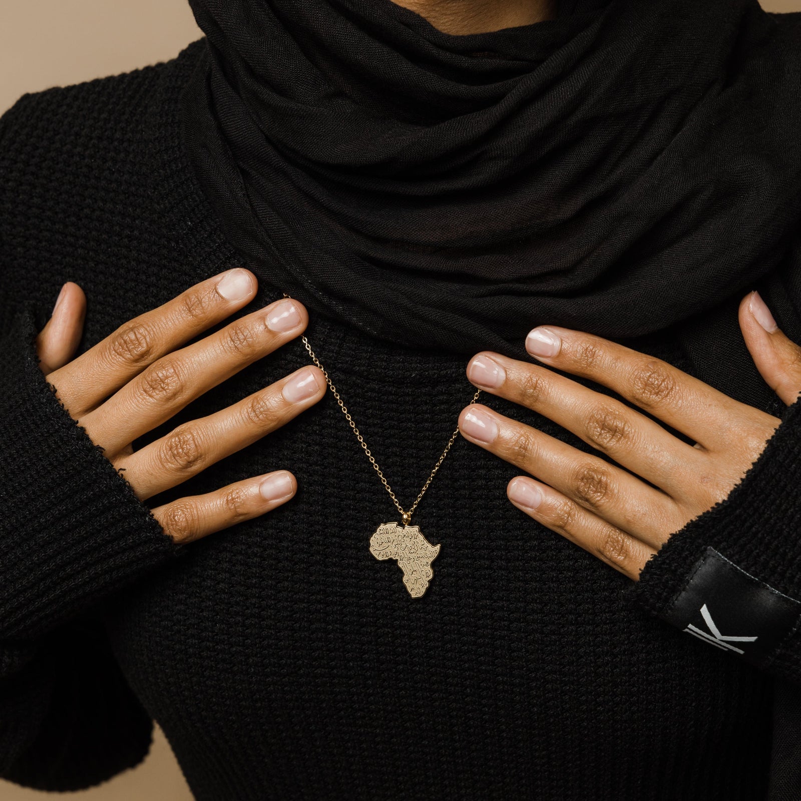 A model wearing the gold-plated Ayatul Kursi Country Map Necklace, with the pendant resting elegantly on her chest, highlighting the intricate design.