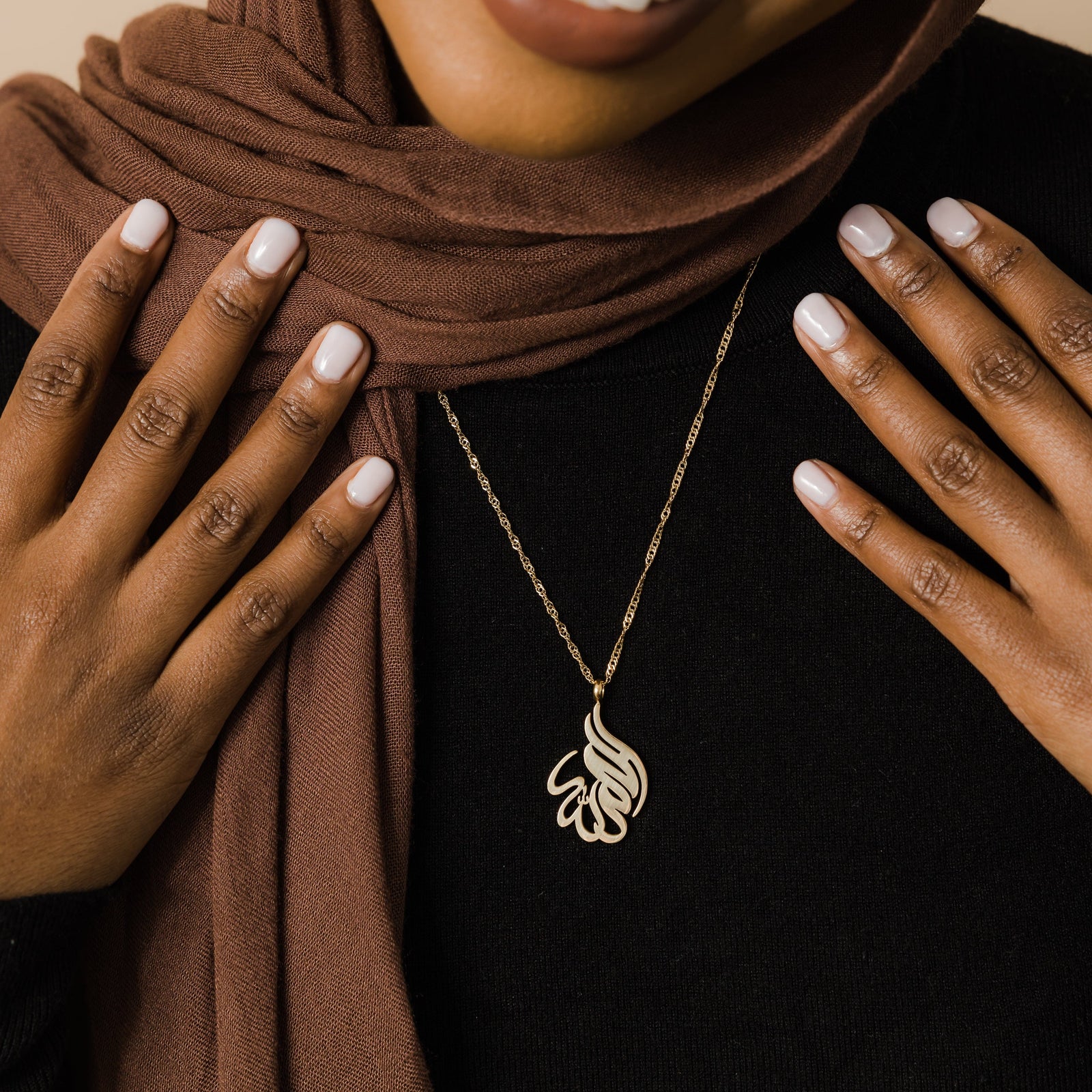 Close up of the Alhamdulillah Calligraphy Necklace as worn by the model.