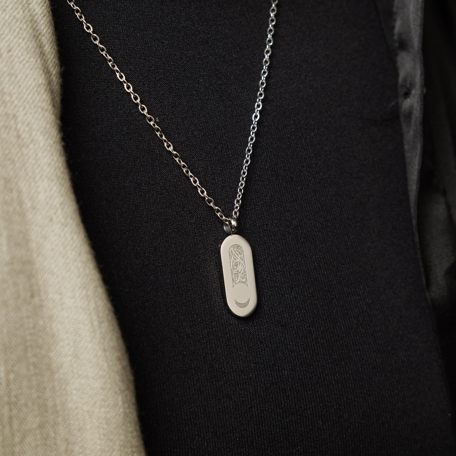 Close up of the silver Alhamdulillah Moon Necklace | Women against the black fabric of the model's clothing.