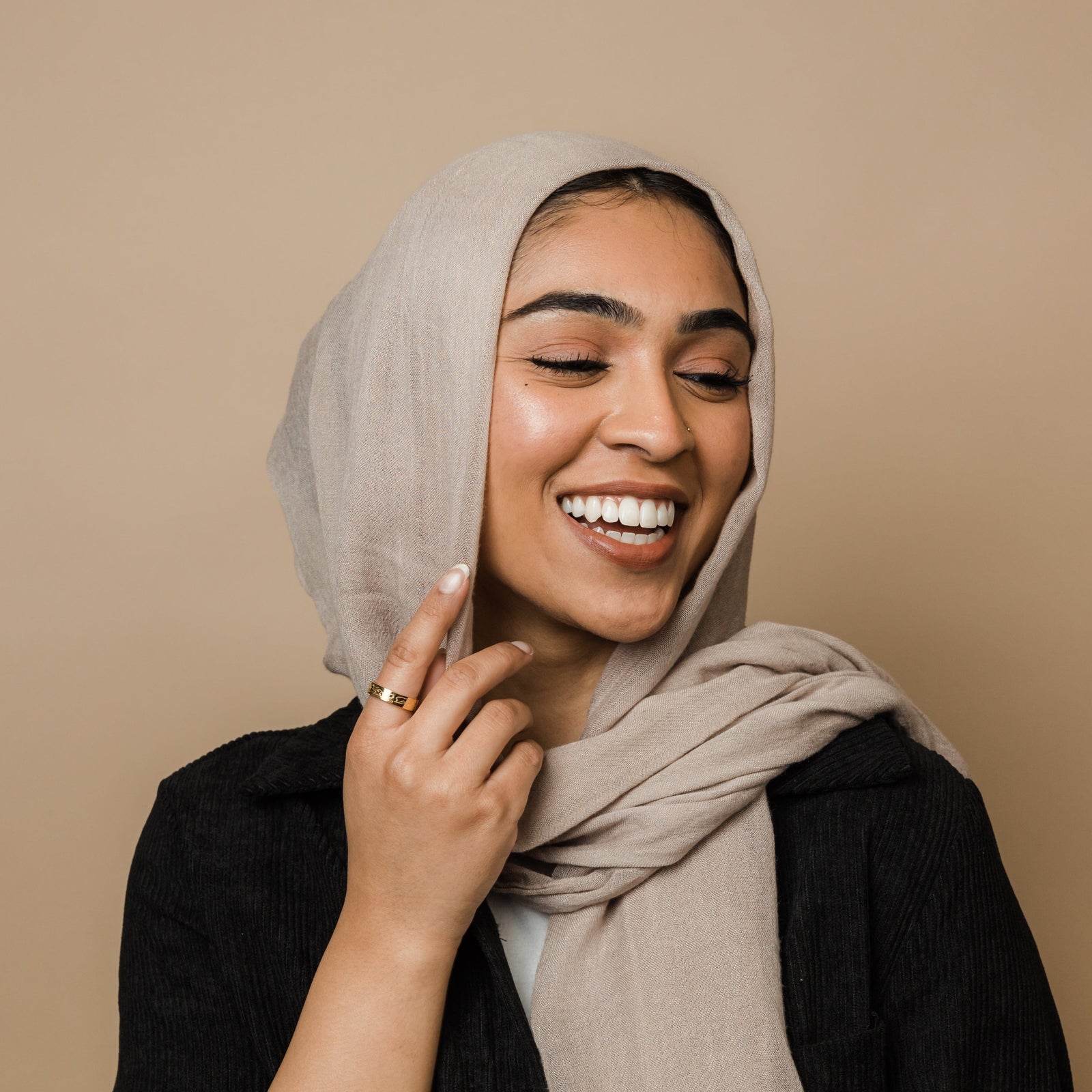 A model wearing the 18K gold-plated "Allah Does Not Burden" ring on her finger. The ring's engraved Arabic inscription is visible.