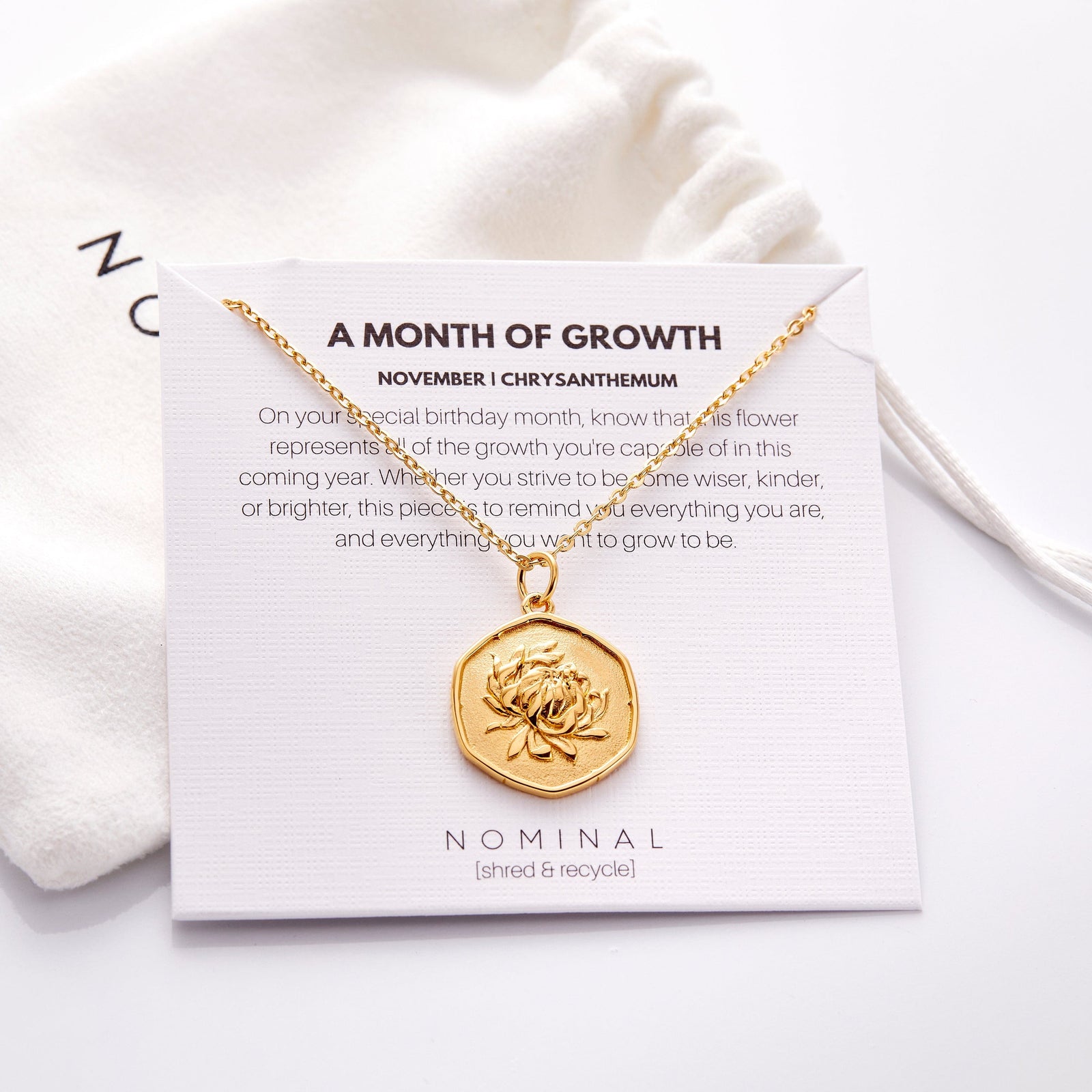 The November | Birth Flower Pendant displayed on its packaging that features the description for the jewelry.