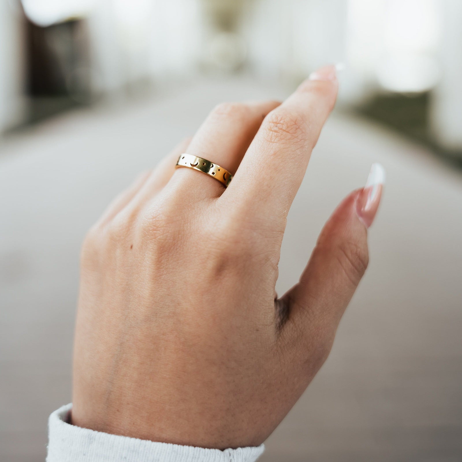 Woman’s hand wearing the gold Stargazer’s Ring with crescent moon and star cutouts