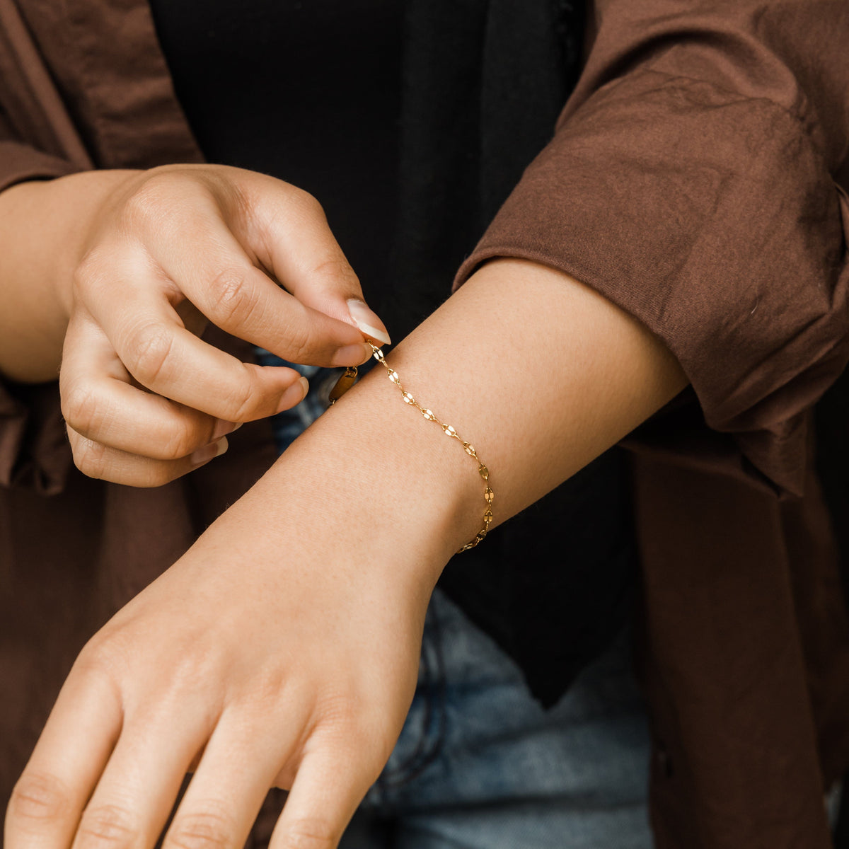 Close-up of woman wearing the flutter bracelet on wrist.