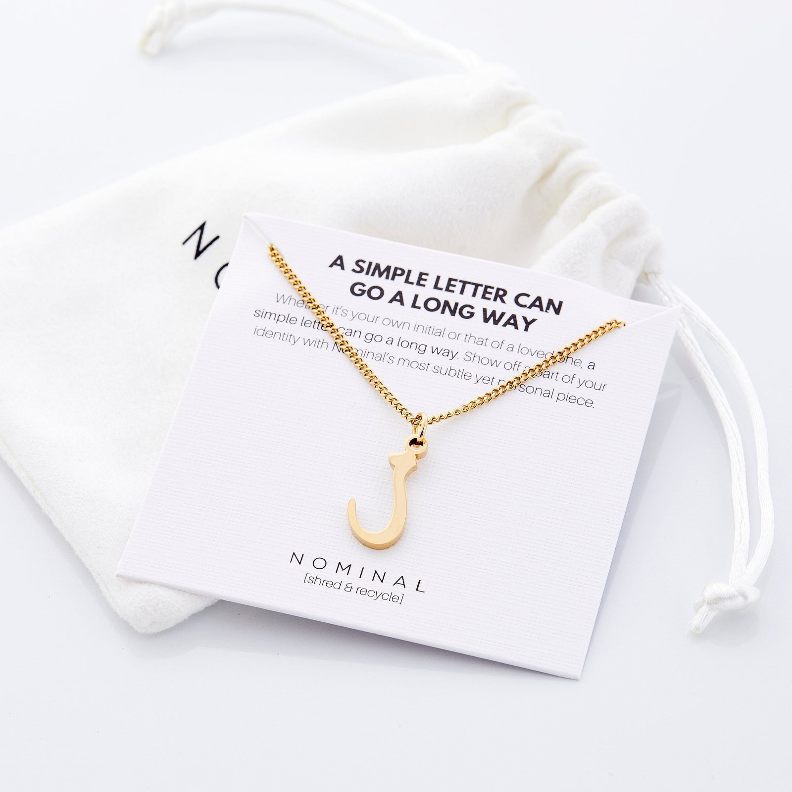 The gold Hanging Arabic Letter Necklace on its packaging.