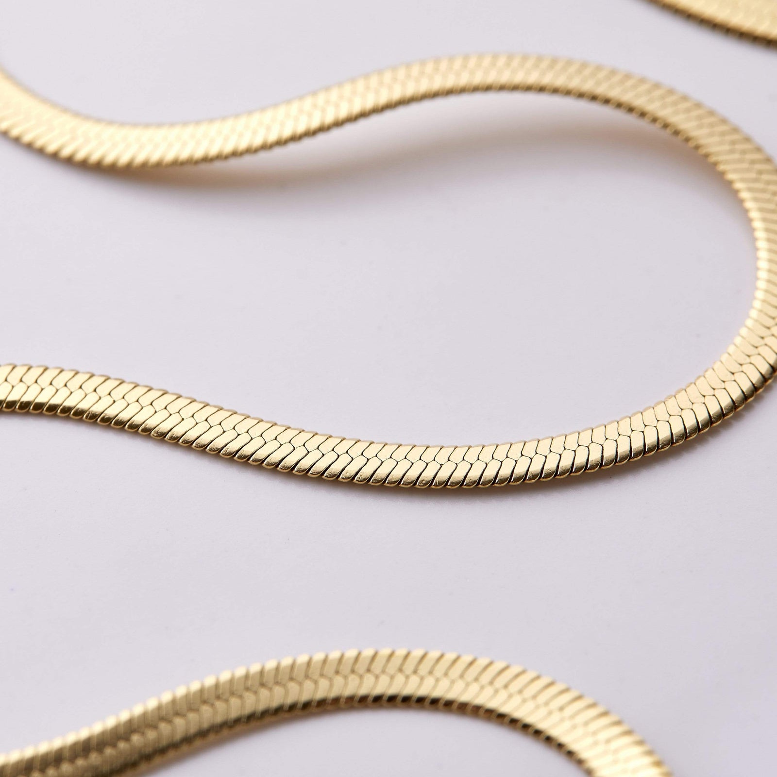 Close up of the design of the gold Herringbone Chain Anklet.