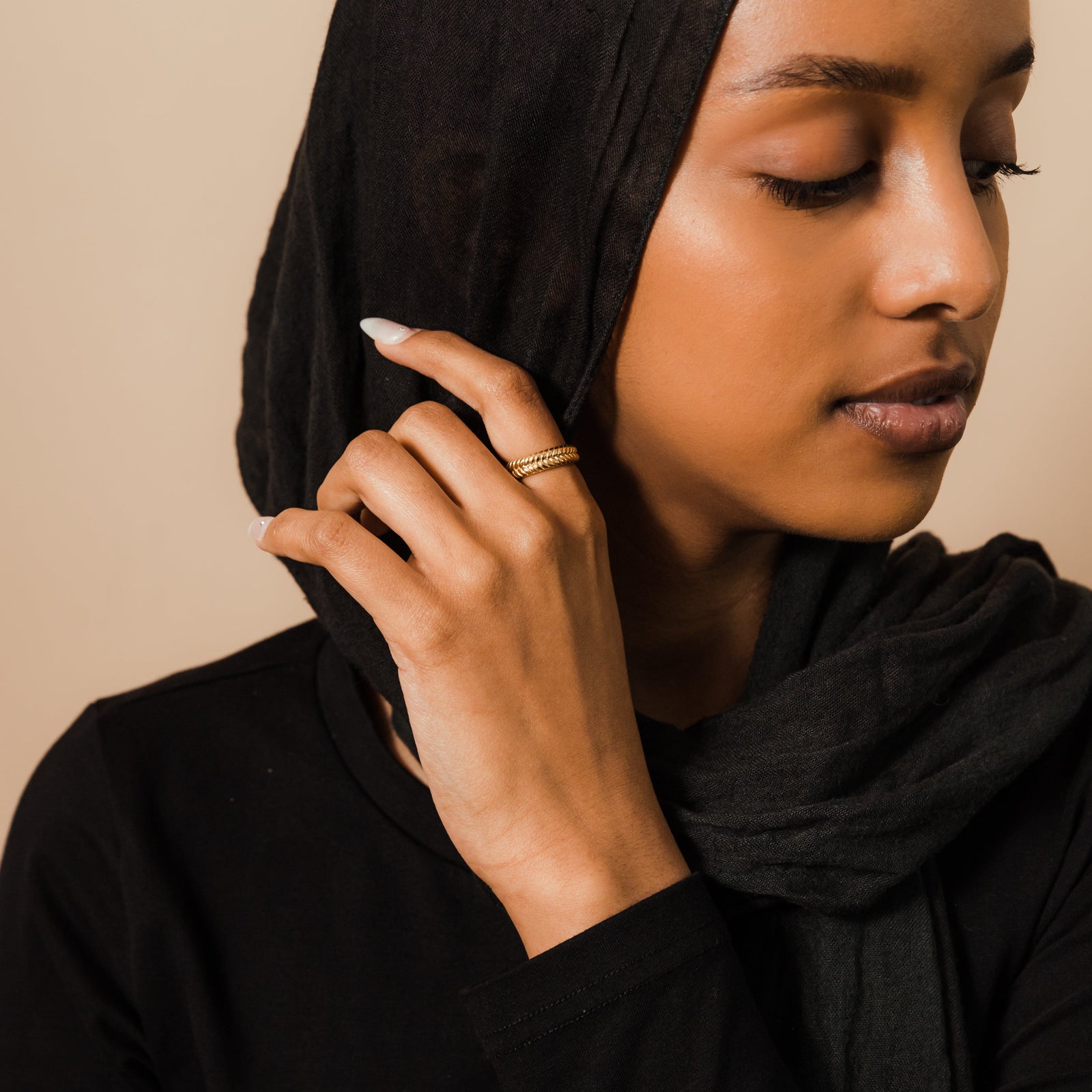 Woman in a black hijab wearing the gold herringbone ring.