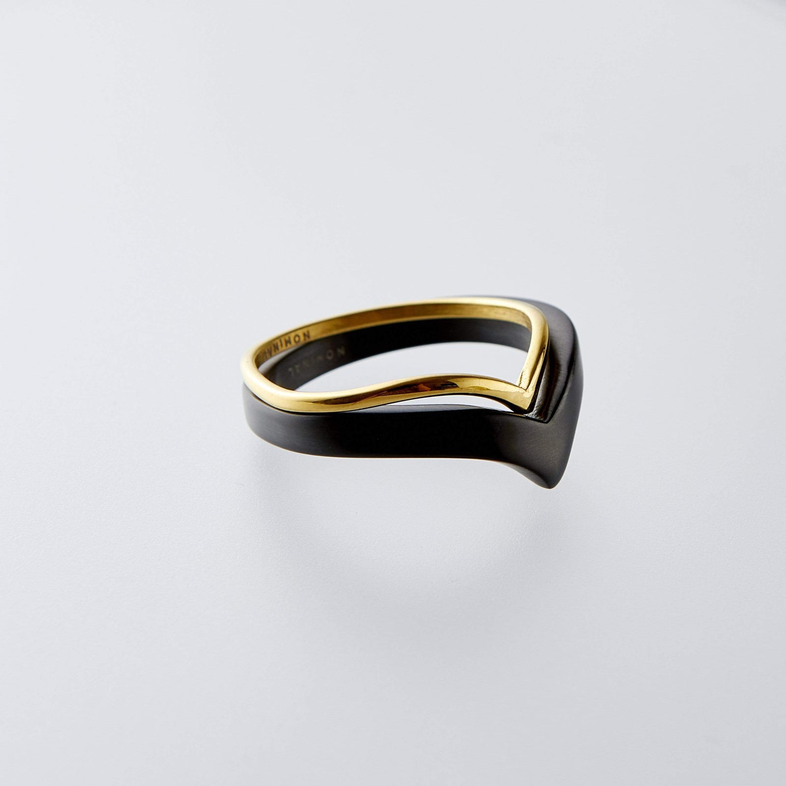 Gold and black completion ring displayed on a clean grey background.