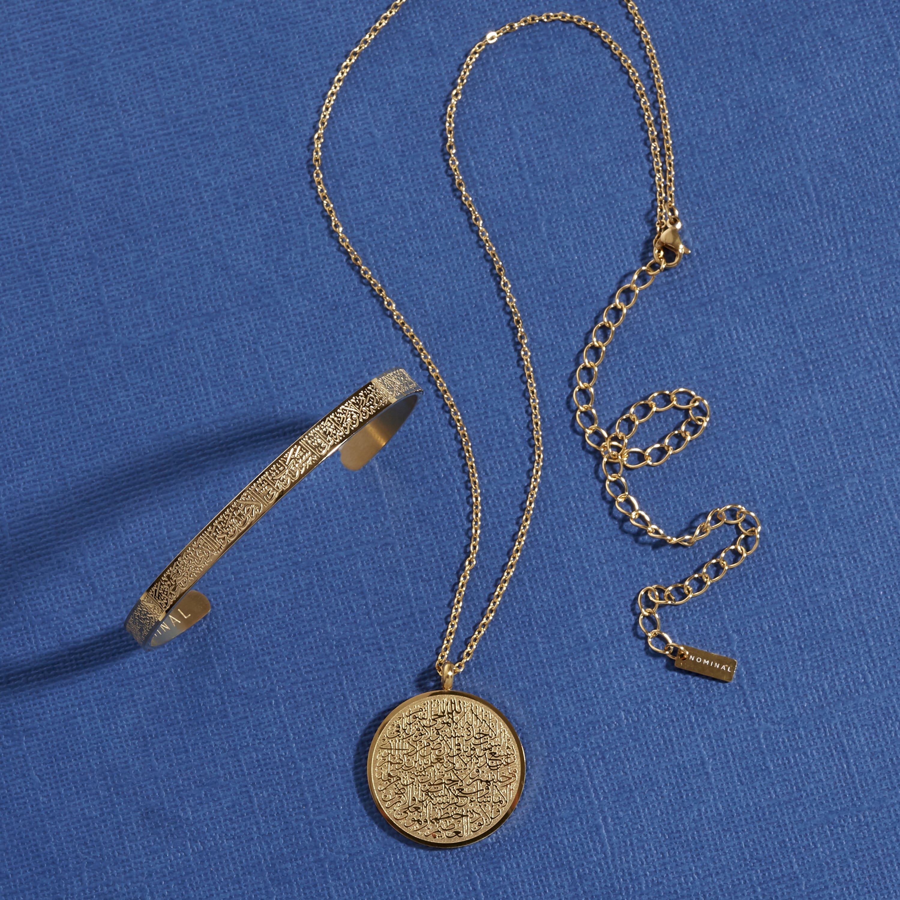 A gold bracelet and necklace on a blue background