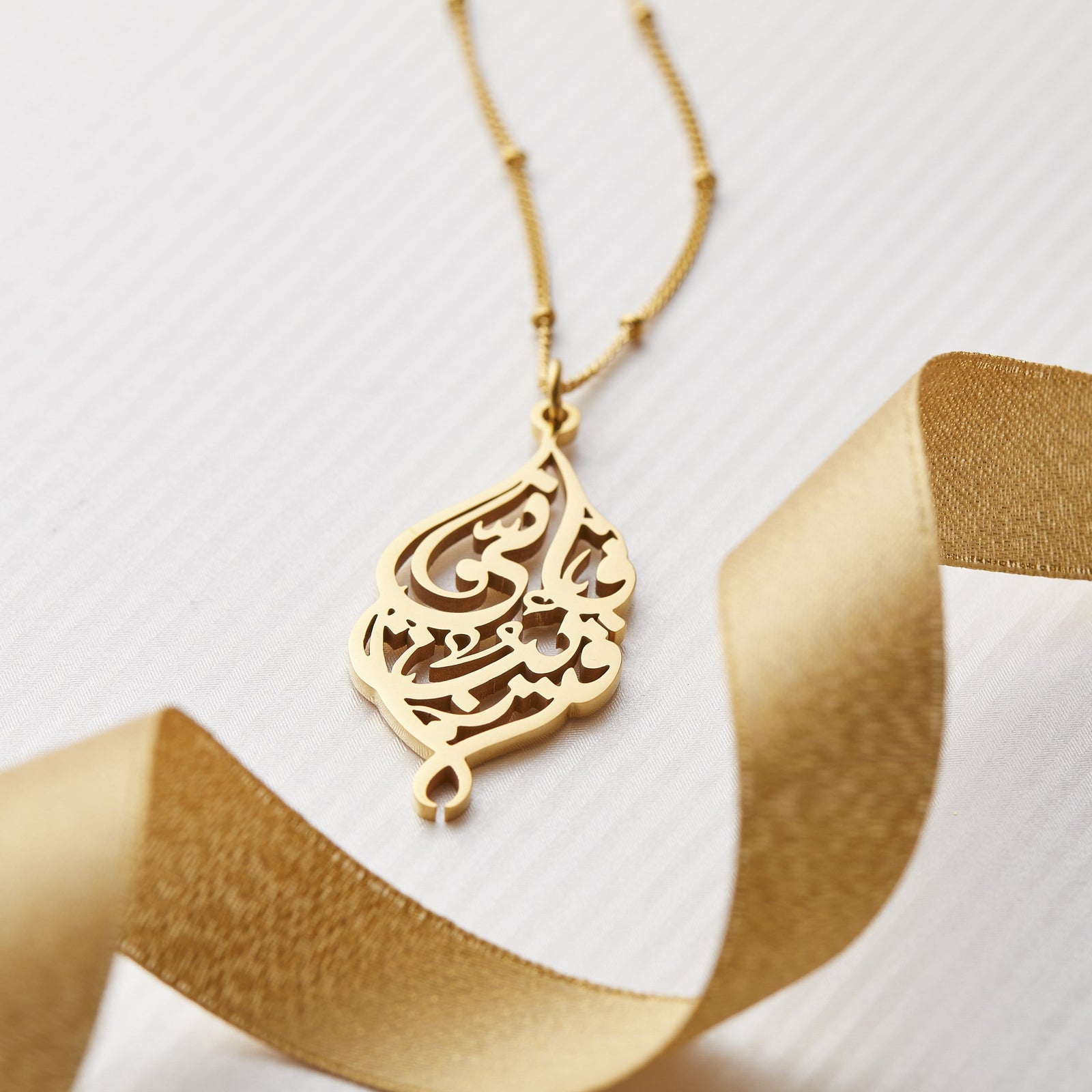 Close up of the pendant of the gold "I Am Near" Necklace