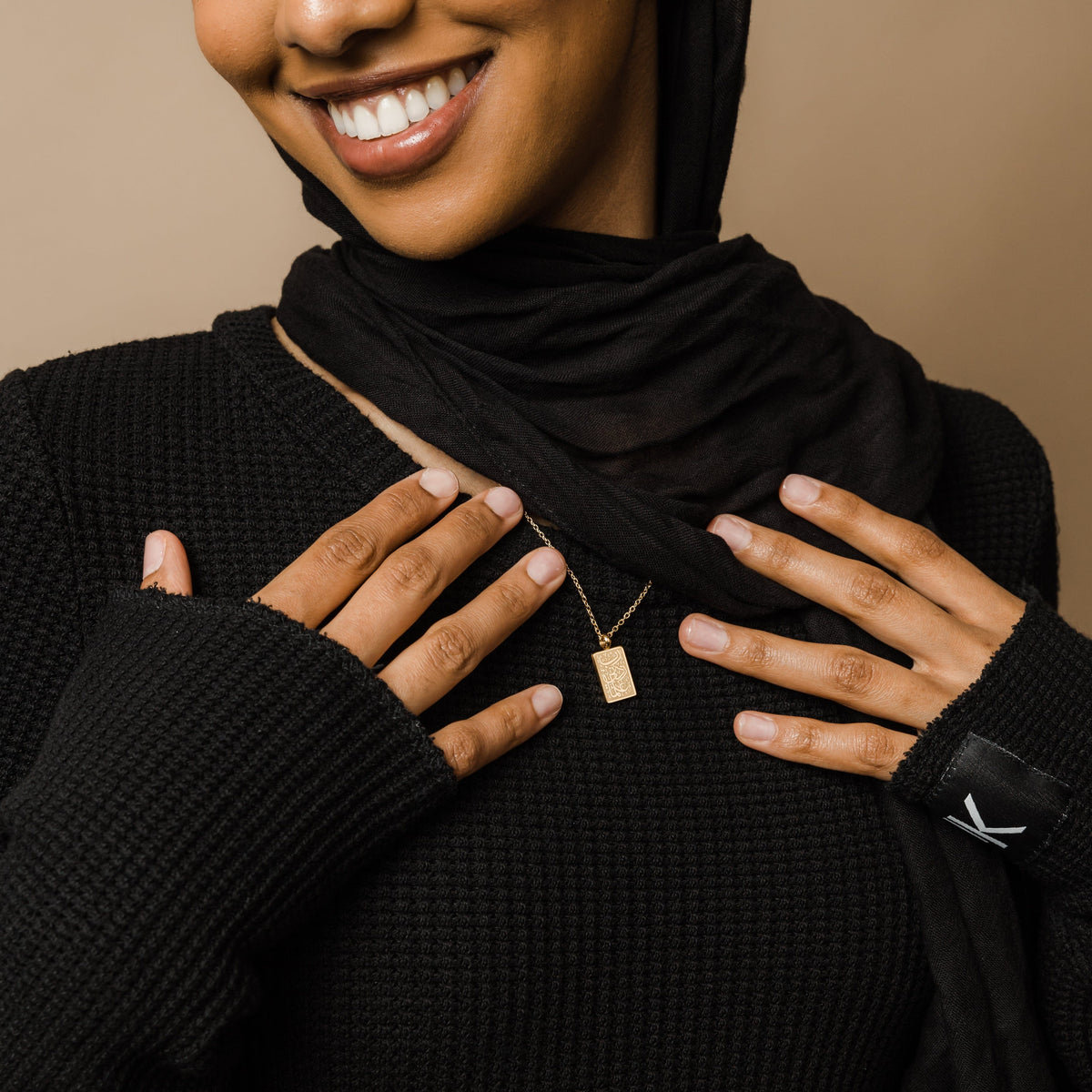 Photo of the model wearing the gold Knowledge Necklace.