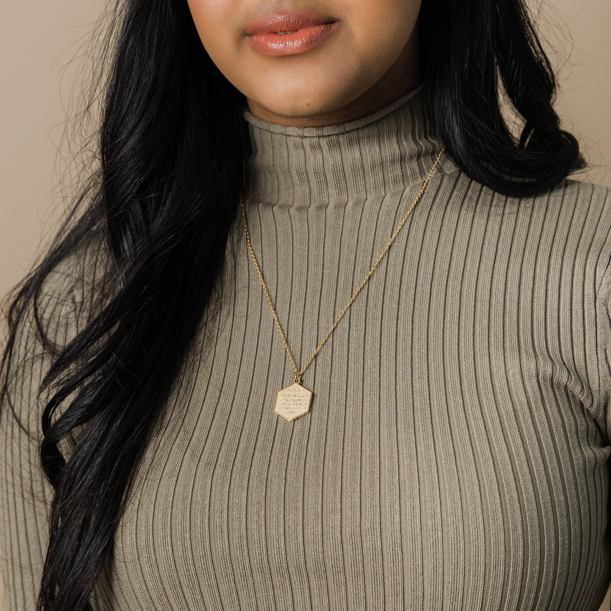 The gold Surat Al-Fatiha Necklace as worn by the model.