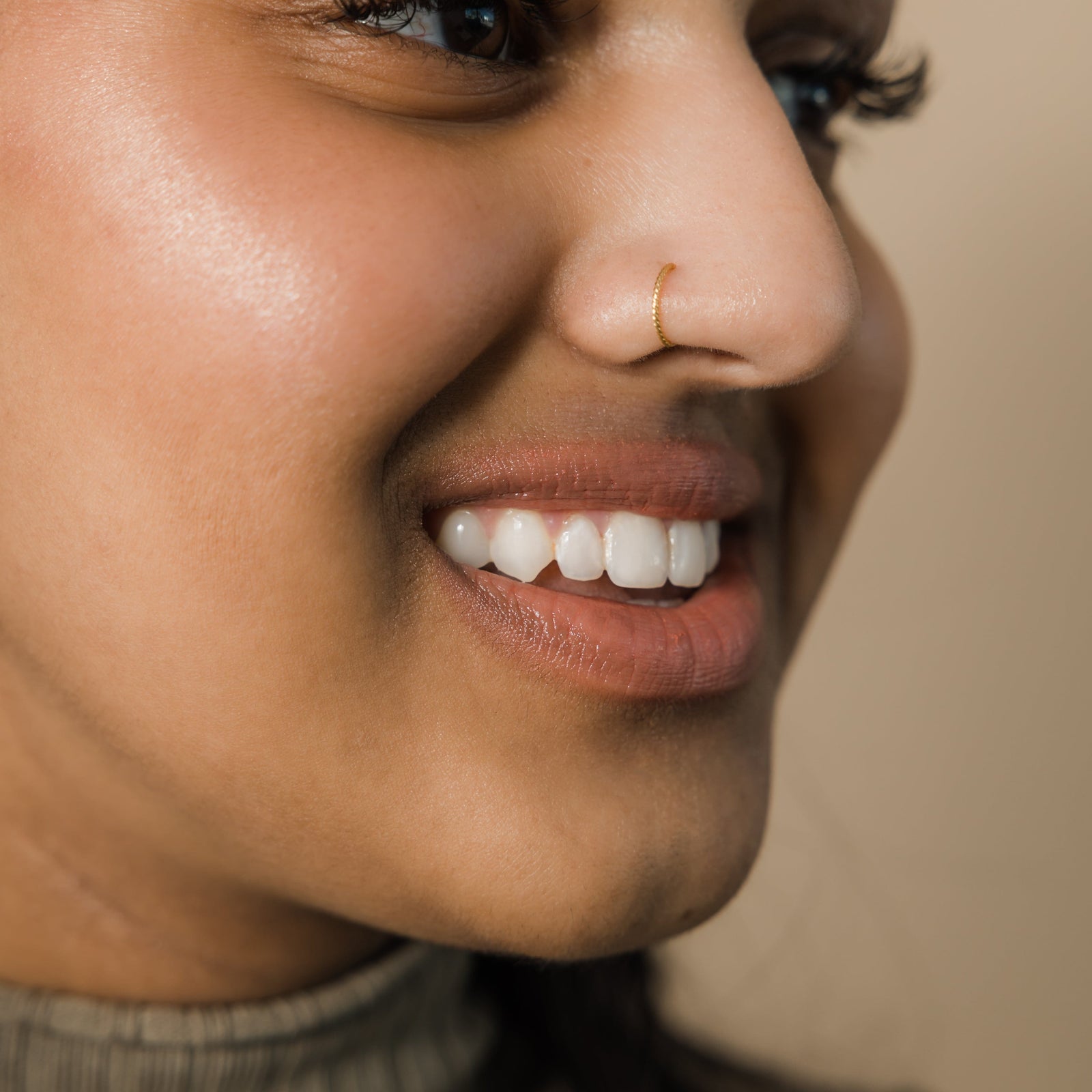 Close up of the golf Twirl Nose Hoop as worn by the model.