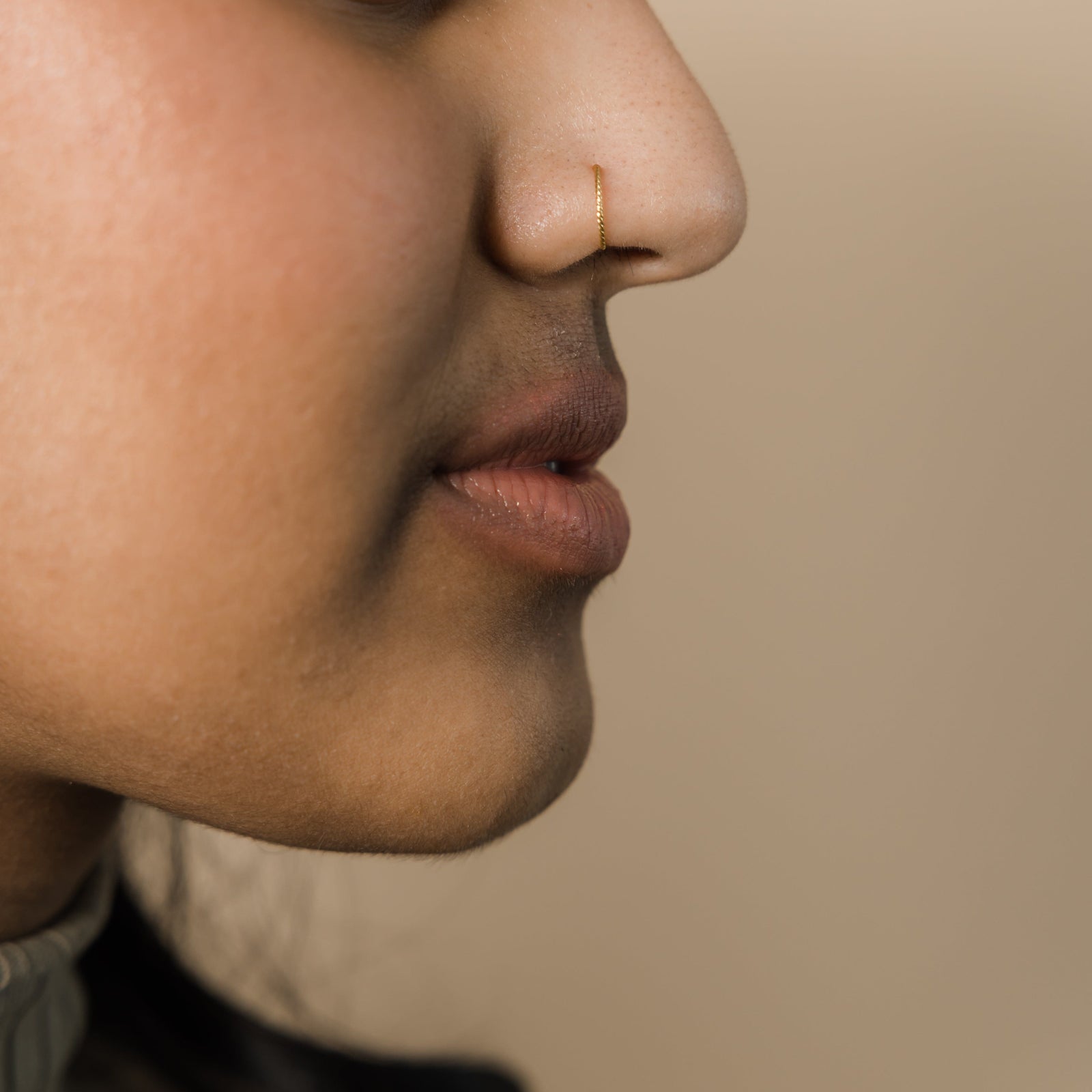 close up of the gold Twirl Nose Hoop as worn by the model