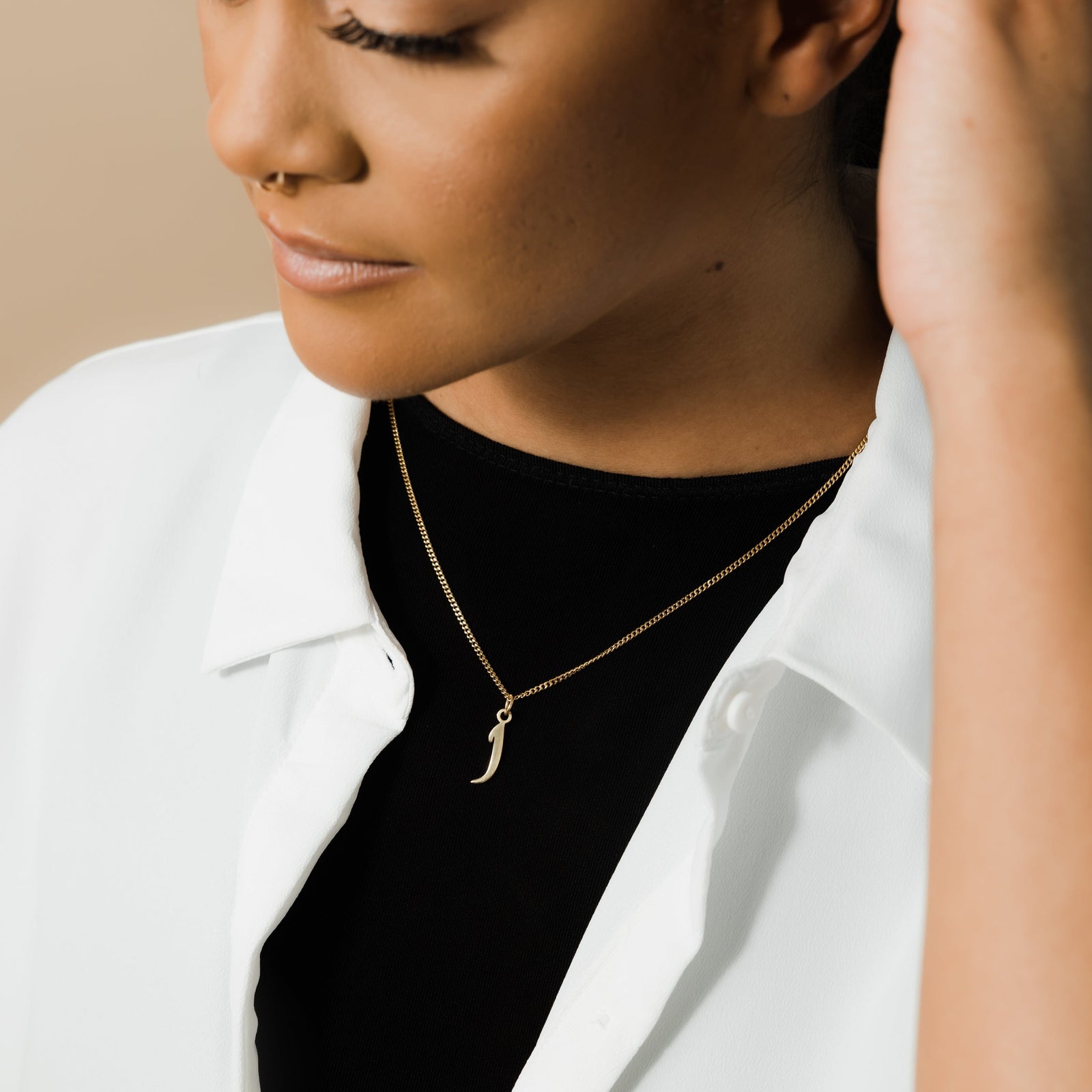 Photo of the model wearing the gold Hanging Arabic Letter Necklace | Women