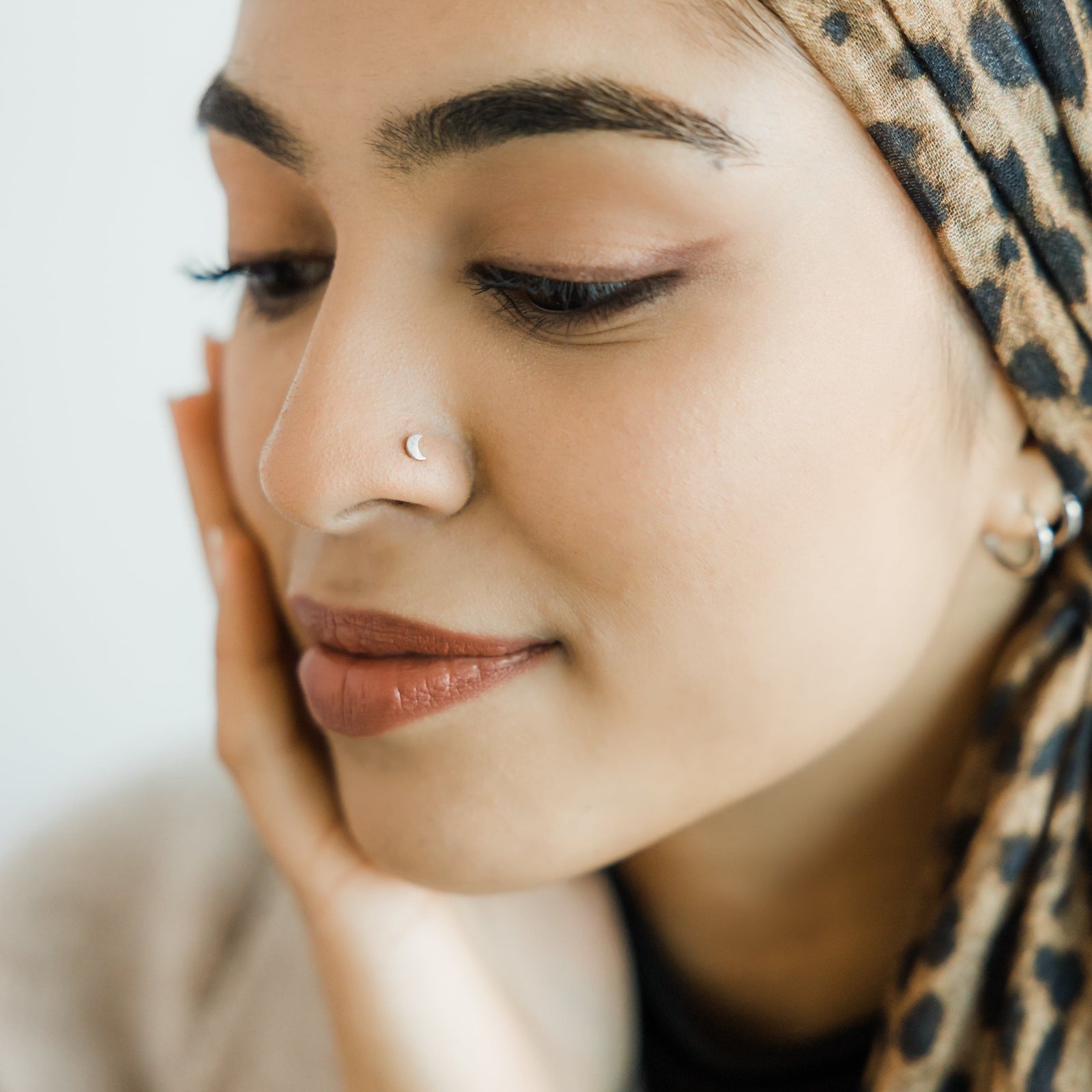 Photo of the model wearing the Crescent Stud Nose Ring.
