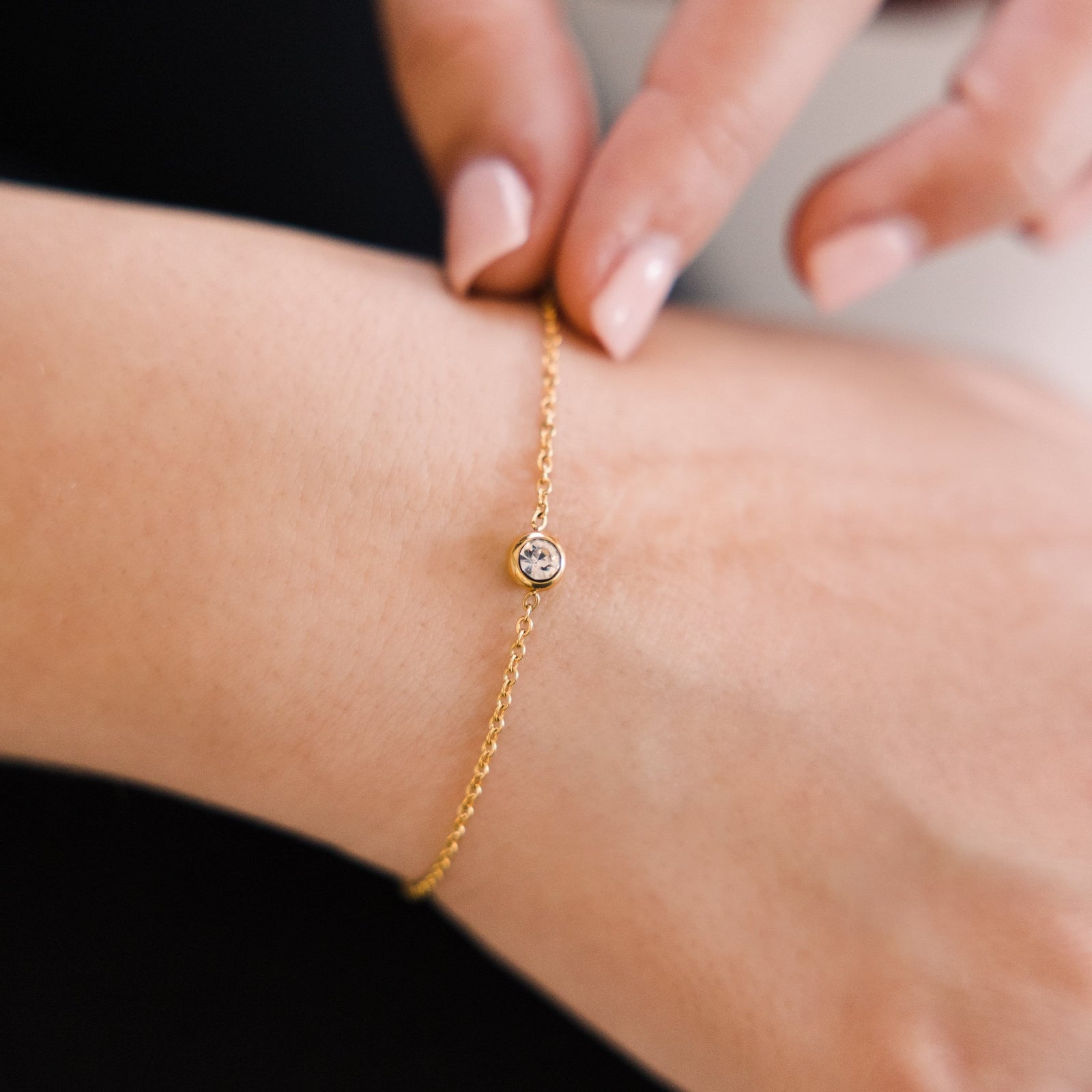 Close up of the gold Bezel Bracelet as worn by the model.