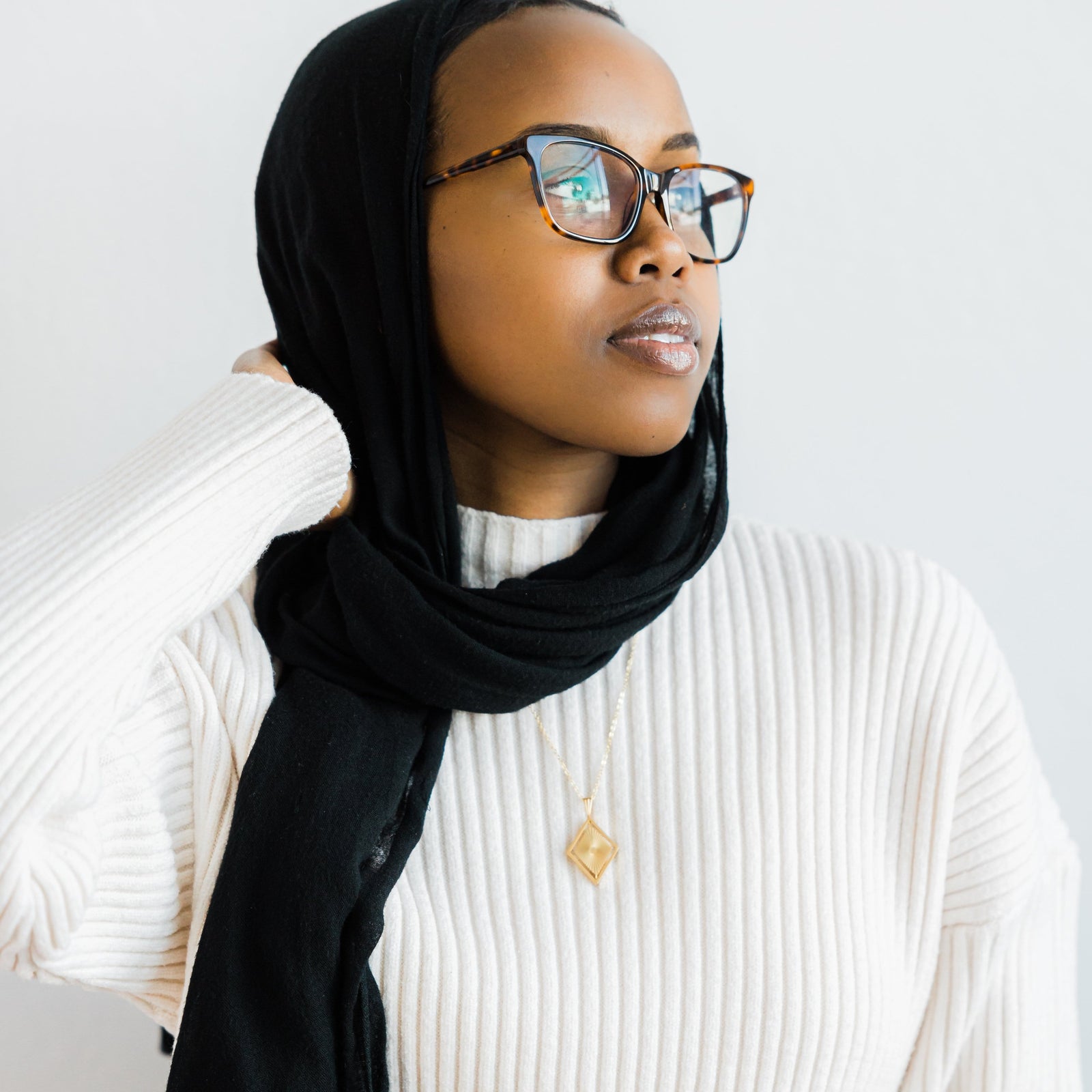 Photo of the model wearing the gold Sun Rays Necklace.