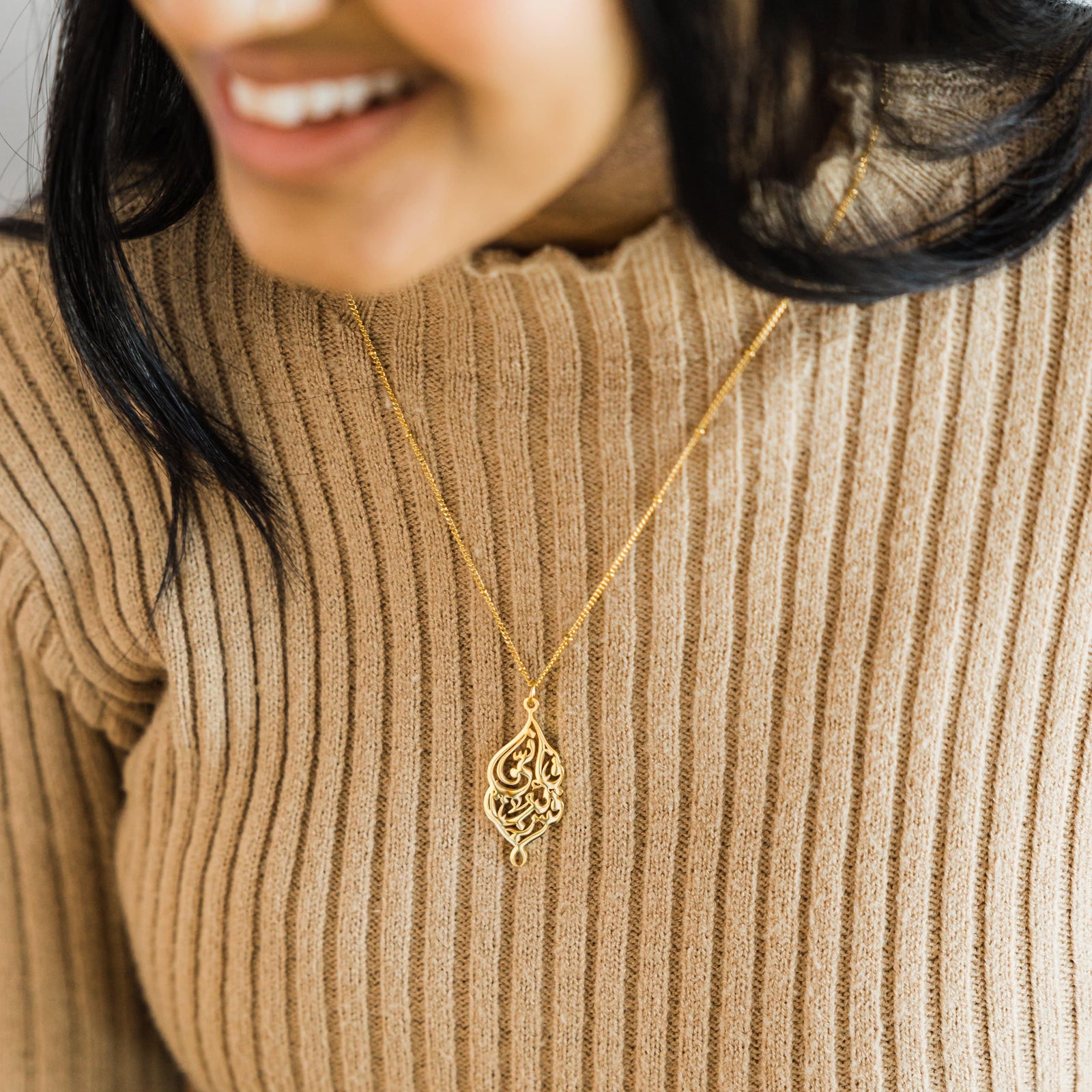 Close up of the gold "I Am Near" Necklace as worn by the model.