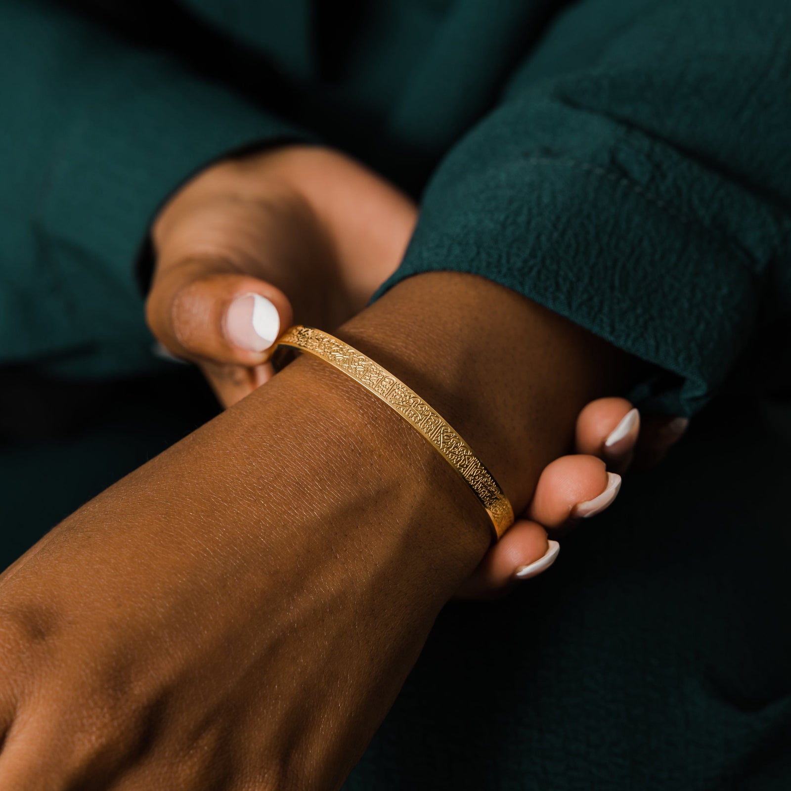 Close up of the gold Ayatul Kursi Cuff as worn by the model on their left hand.