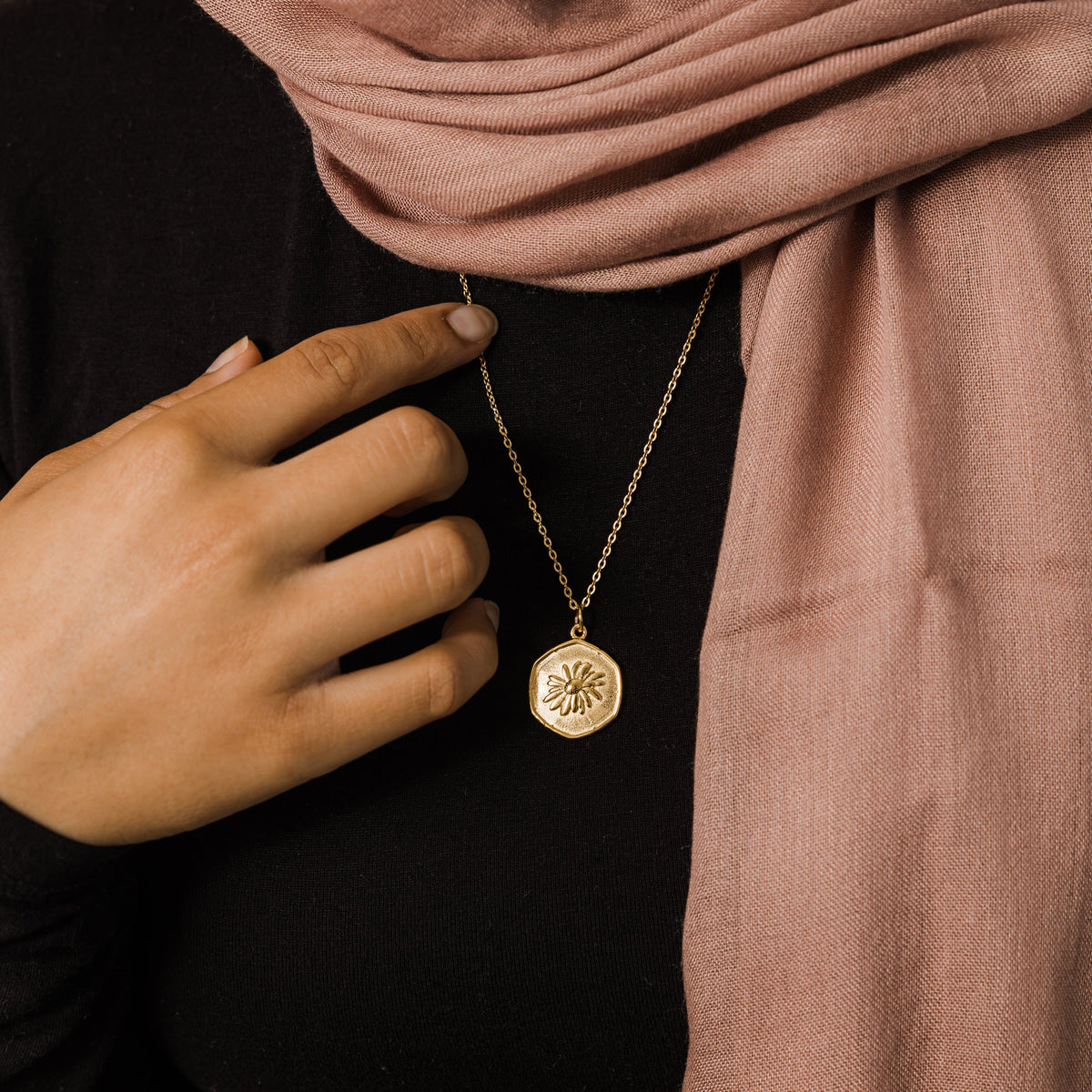 Close up of the gold April | Birth Flower Pendant as worn by the model.