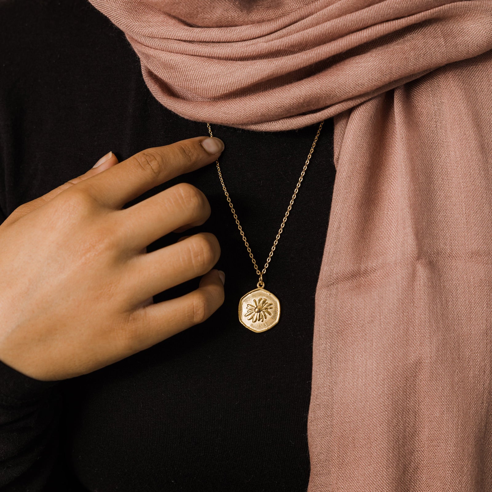 Close up of the gold April | Birth Flower Pendant as worn by the model.